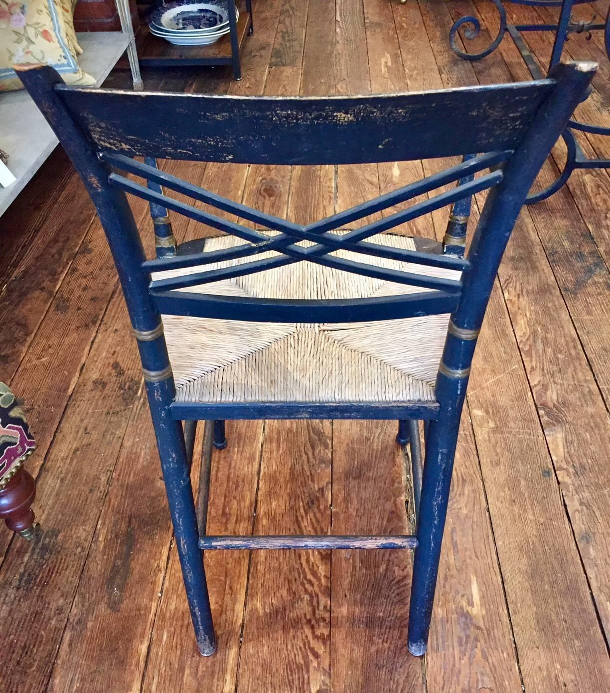An early 1900s Hitchcock style black and gold hand-painted chair oozing with charm and character, naturally distressed with newer rush seat in great condition. Seat height 17.5