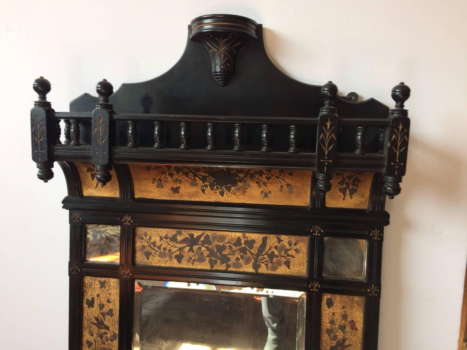 Beautiful antique mirror or Victorian what not" shelf, having painted panels with gold backgrouds around a central bevelled mirror, plus an elaborate ebonized wood gallery at the top.
