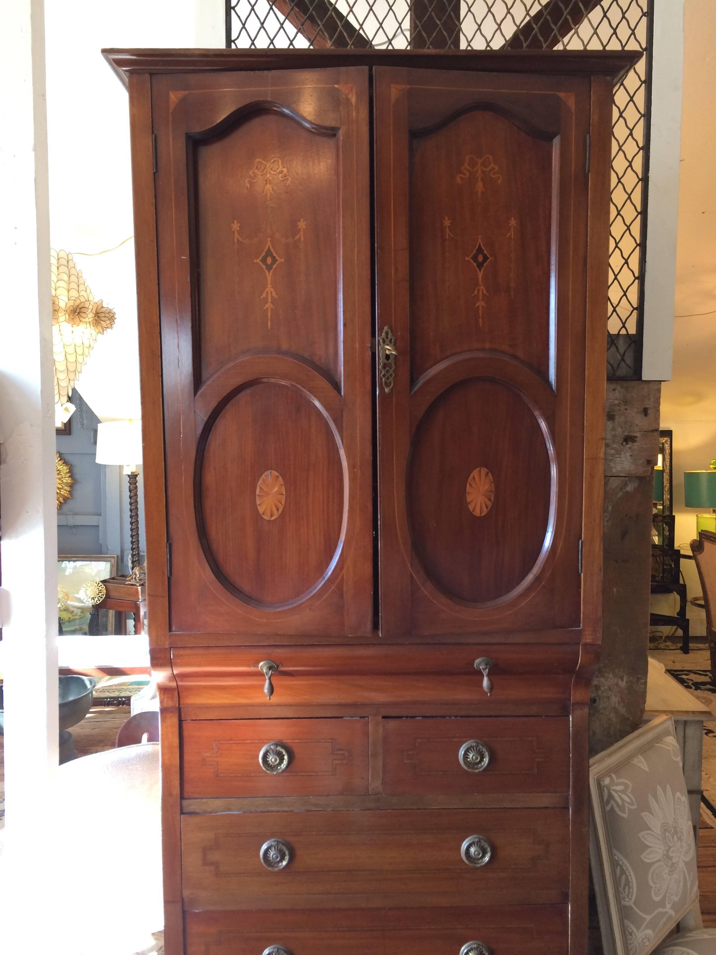English antique tall cabinet/linen press in mahogany with string inlay. Doors open over a 1.5 inch drawer, one split set of drawers, and four single drawers. All hardware is original and door to cabinet locks with a key. Detailed string inlay on