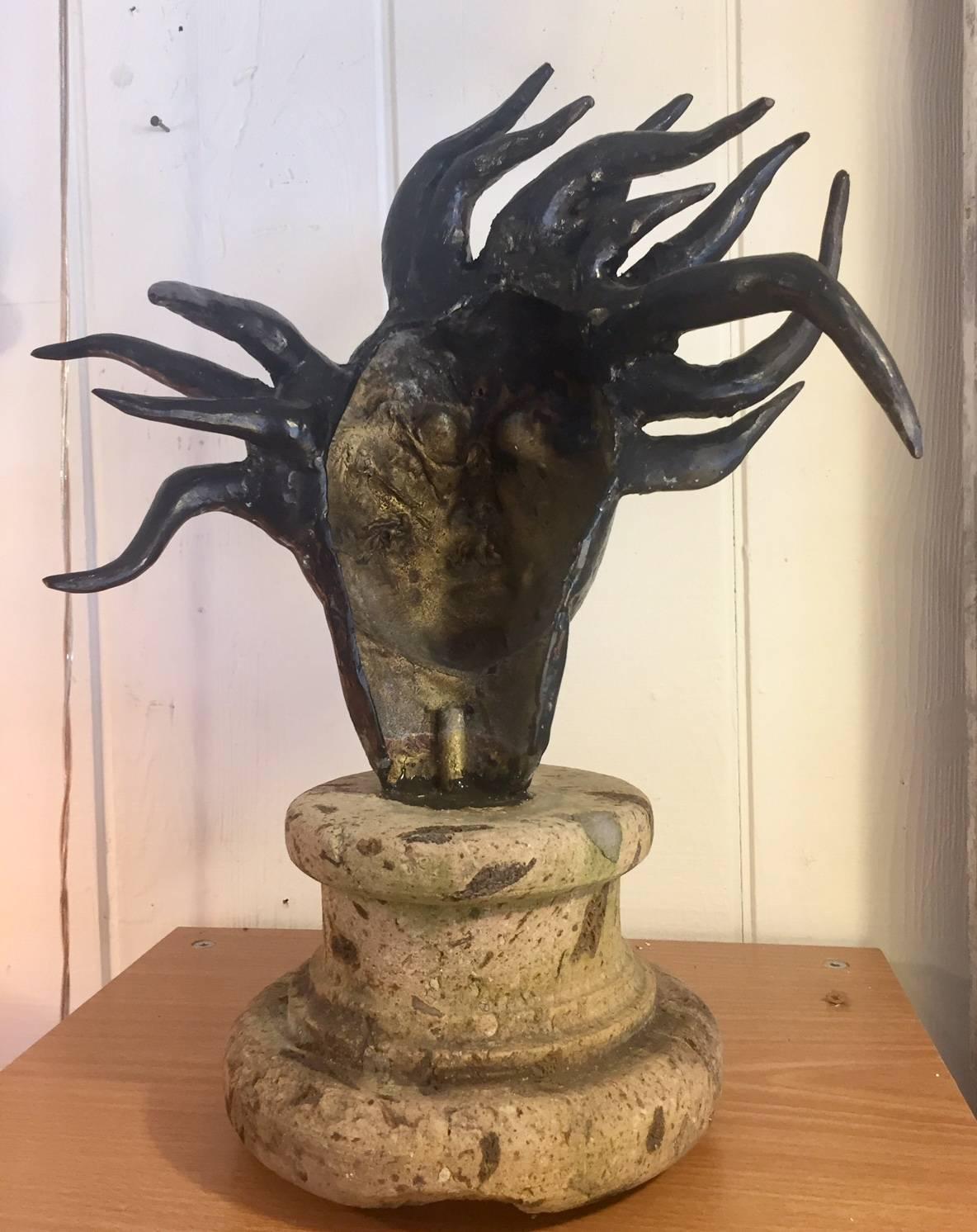 Eye catching sculpture of a face that has a powerful mythical feel,...possibly Medusa, mounted on a stone base.
Measures: Base:
8
