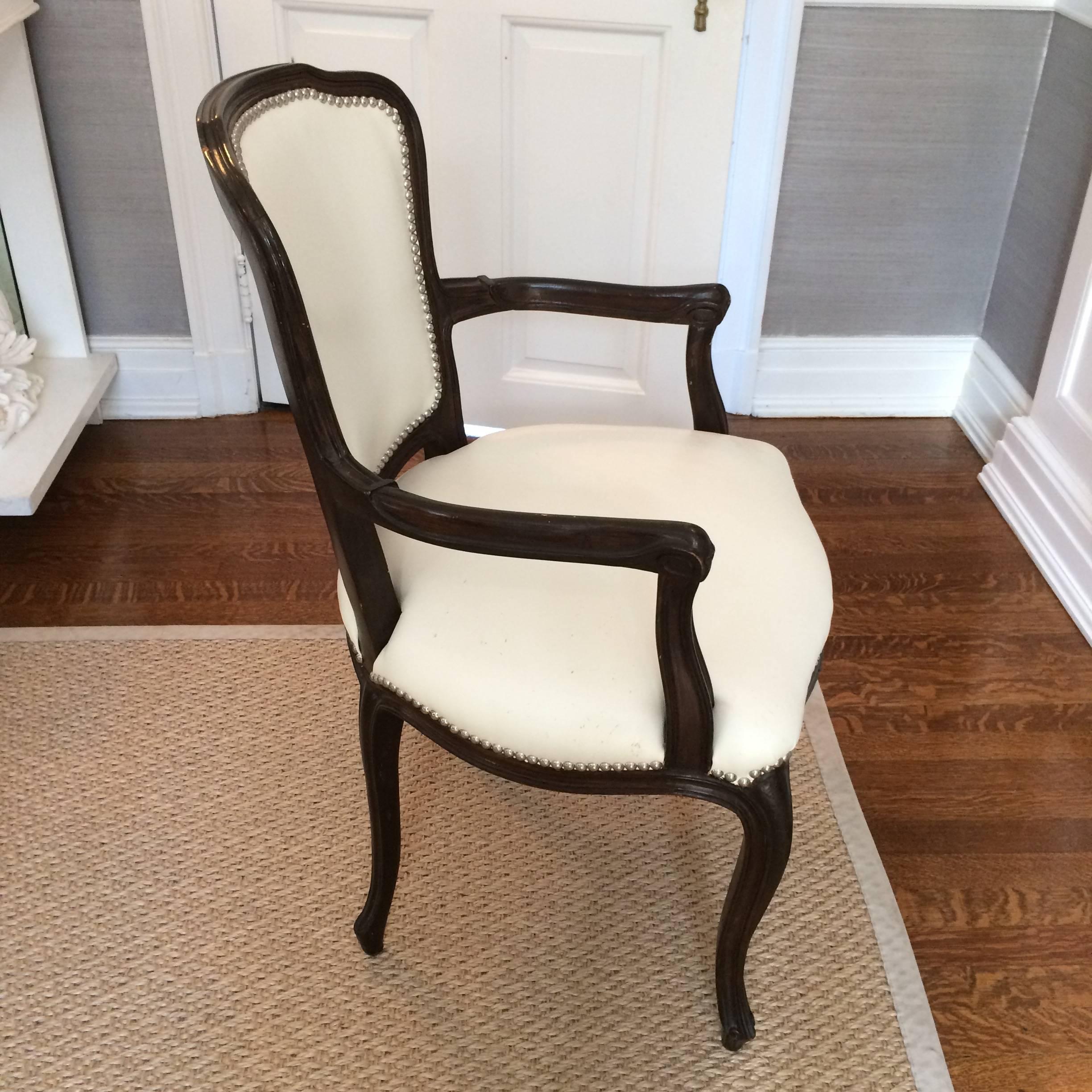 Stylish set of ten vintage French style dining chairs, four armchairs and six side chairs, having very dark brown wood and glamorized with white leather upholstery and silver nailheads.
Note: Two armchairs and four side chairs are in very good