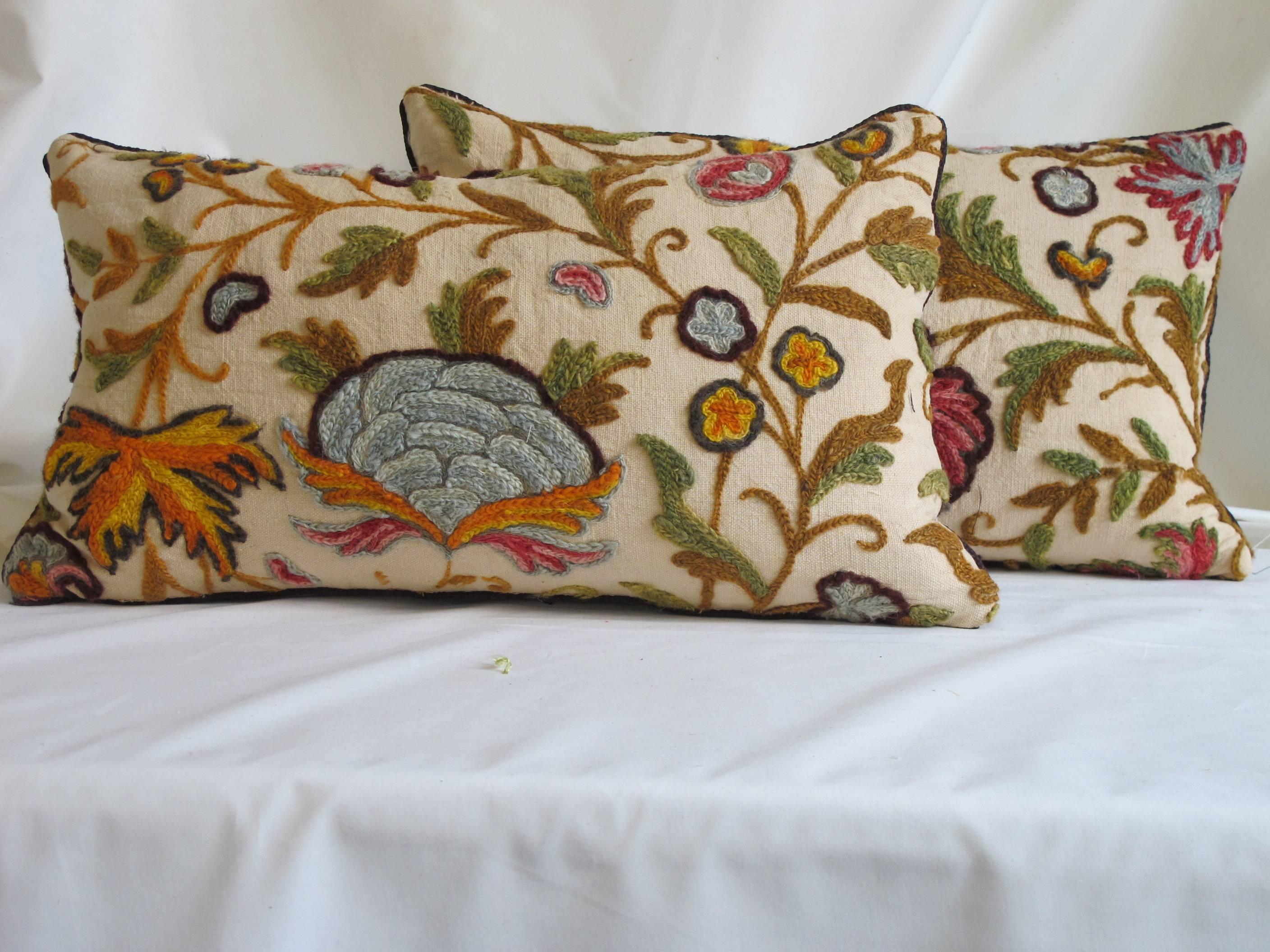 Lovely pair of pillows made from a circa 1950s hand-stitched crewel, in vibrant multi colors, backed with a coordinating velvet, hidden zipper closure, down insert included.