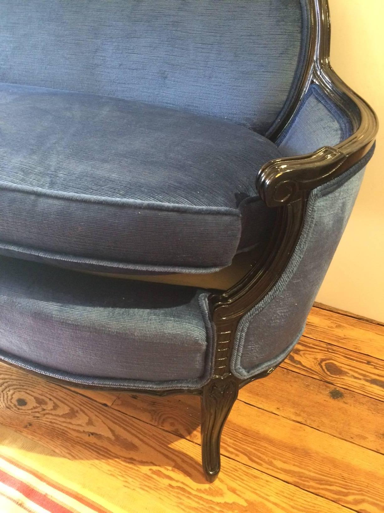 Classic elegant French vintage loveseat that's been glamorized with black glossy paint on the carved wood frame, and luxuriously outfitted in royal blue velvet.
