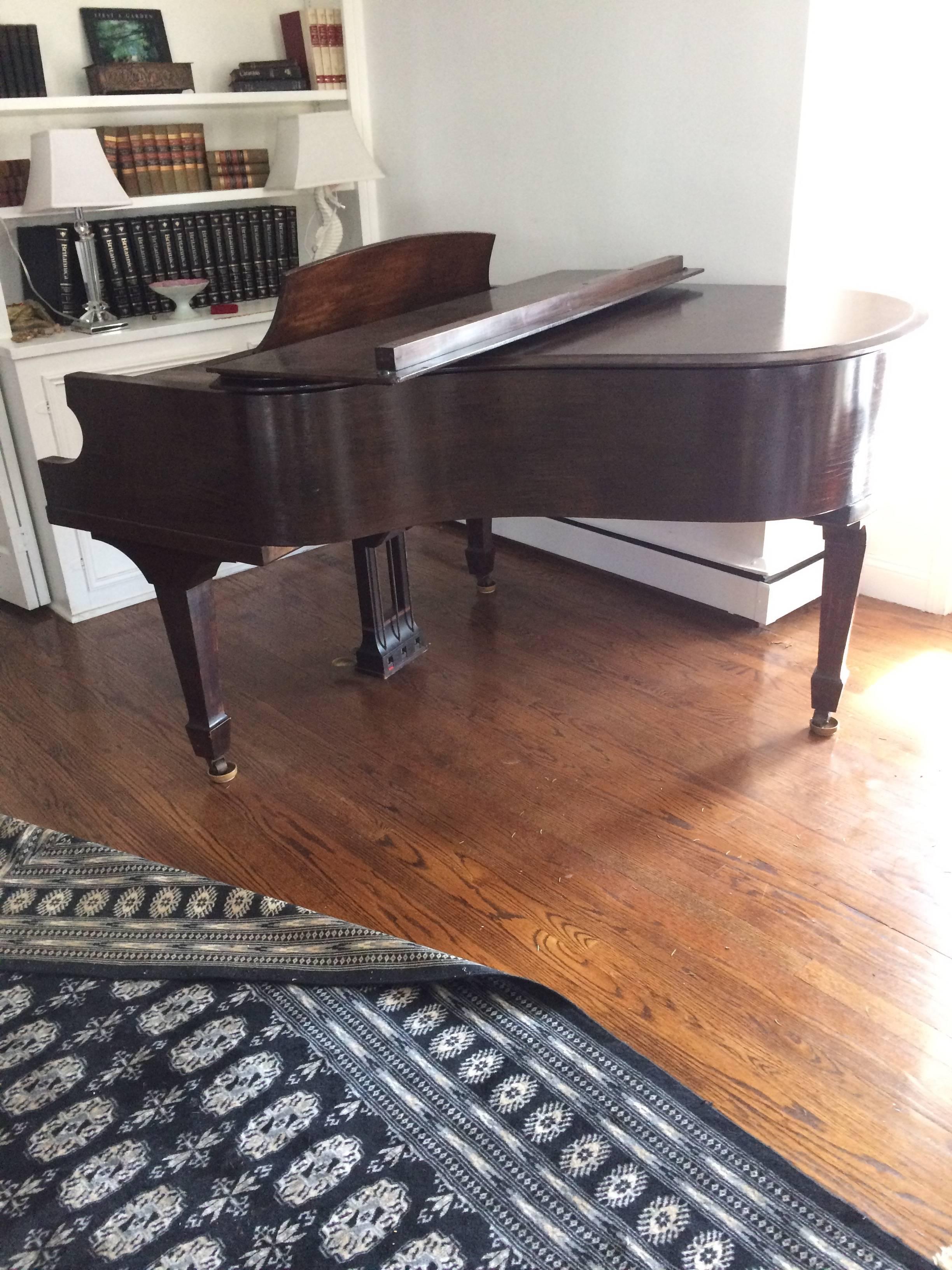 Well loved baby grand piano in a gorgeous dark wood with handsome brass chickering label on the front and painted shield inside. Last tuned in 2014, good working order. Measures: Apron height 23.75.