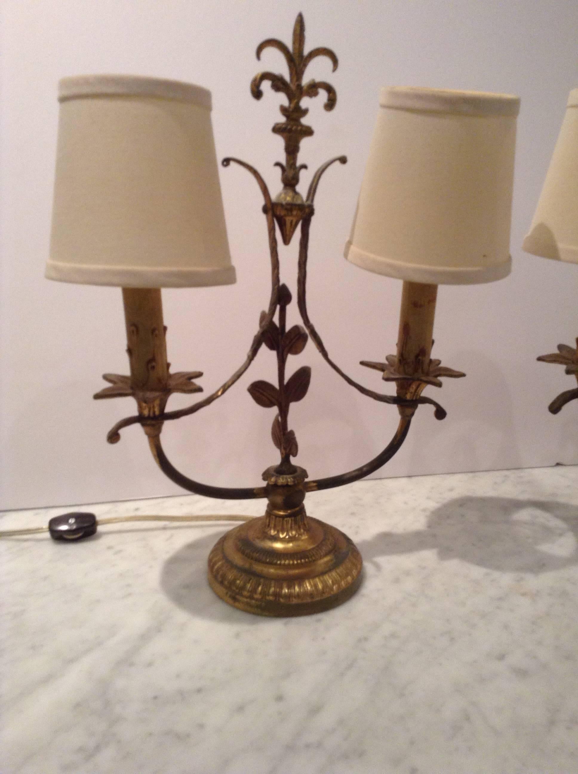 Beautiful pair of antique French lamps in gilt metal in a leaf and feather-like design. Off-white fabric shades.