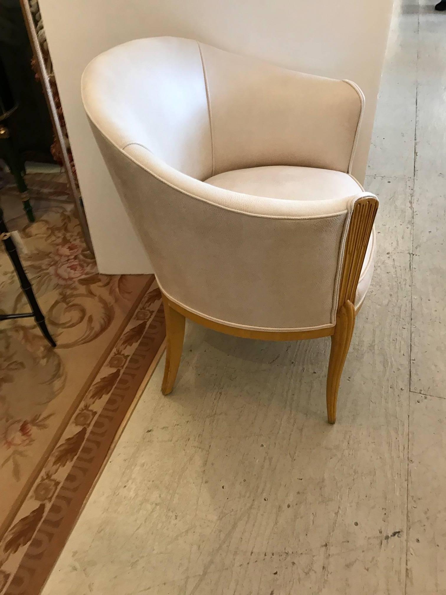 Glamorous deco chair with lovely blonde carved wood, curved on the back and newly updated with neutral tone on tone faux snakeskin upholstery and double welting. Seat depth 19".