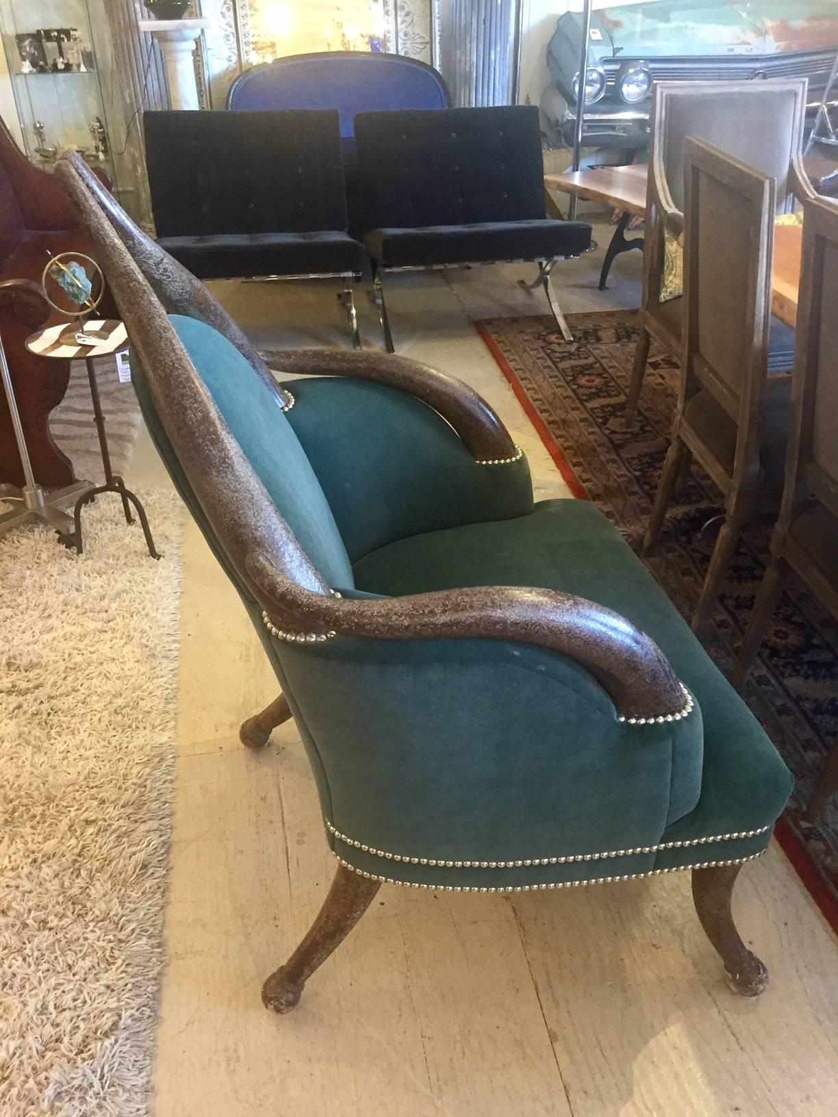 The chair that steals the show in the room, a striking faux Horn armchair upholstered in rich teal velvet with a shagreen pattern, finished with brass nailheads.
