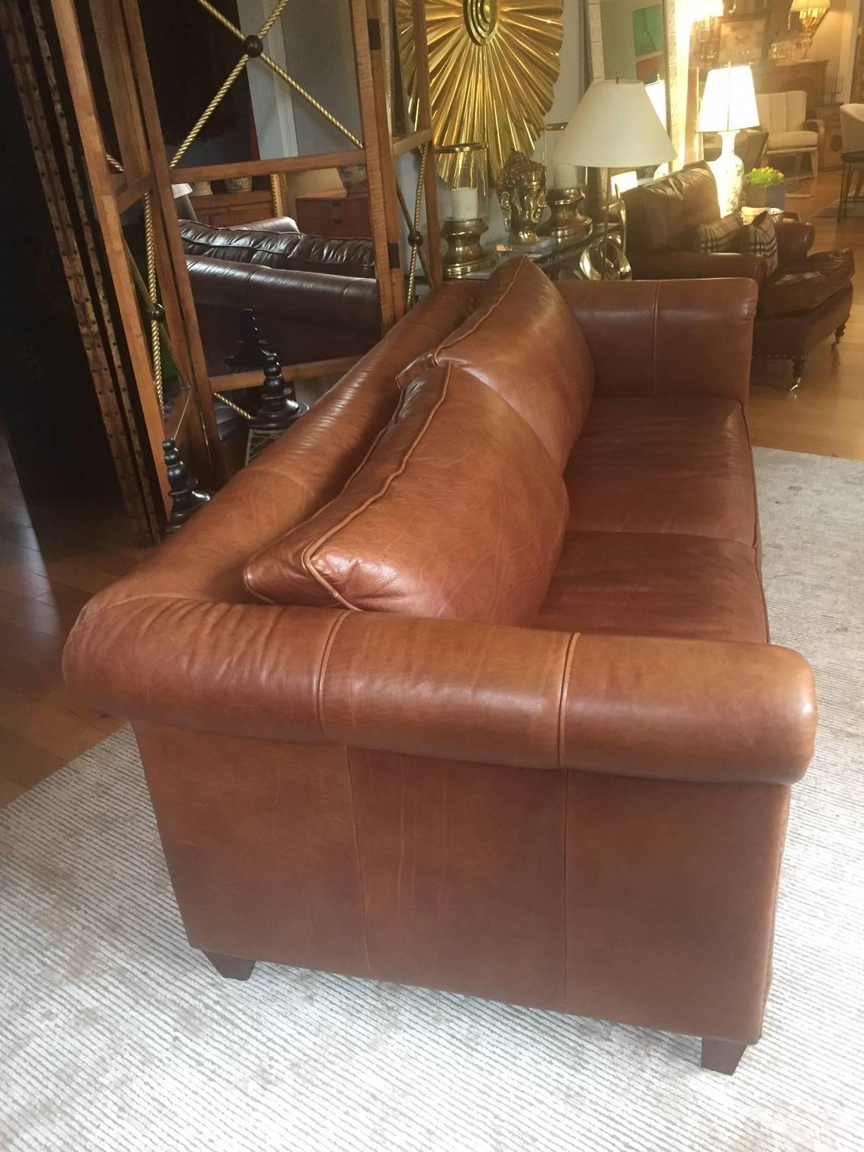 Handsome soft brown leather sofa, quite large, with two seat cushions and two back cushions, recently restuffed. Finished with hobnails on the front of the curved arms. Measures: 19 seat height 32 arm height.