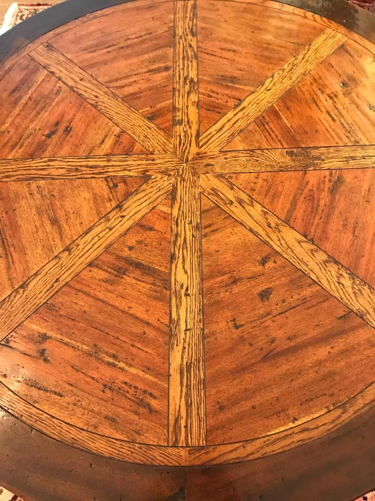 Beautiful tilt-top round table having gorgeous mixed wood inlaid top with darker wood periphery.