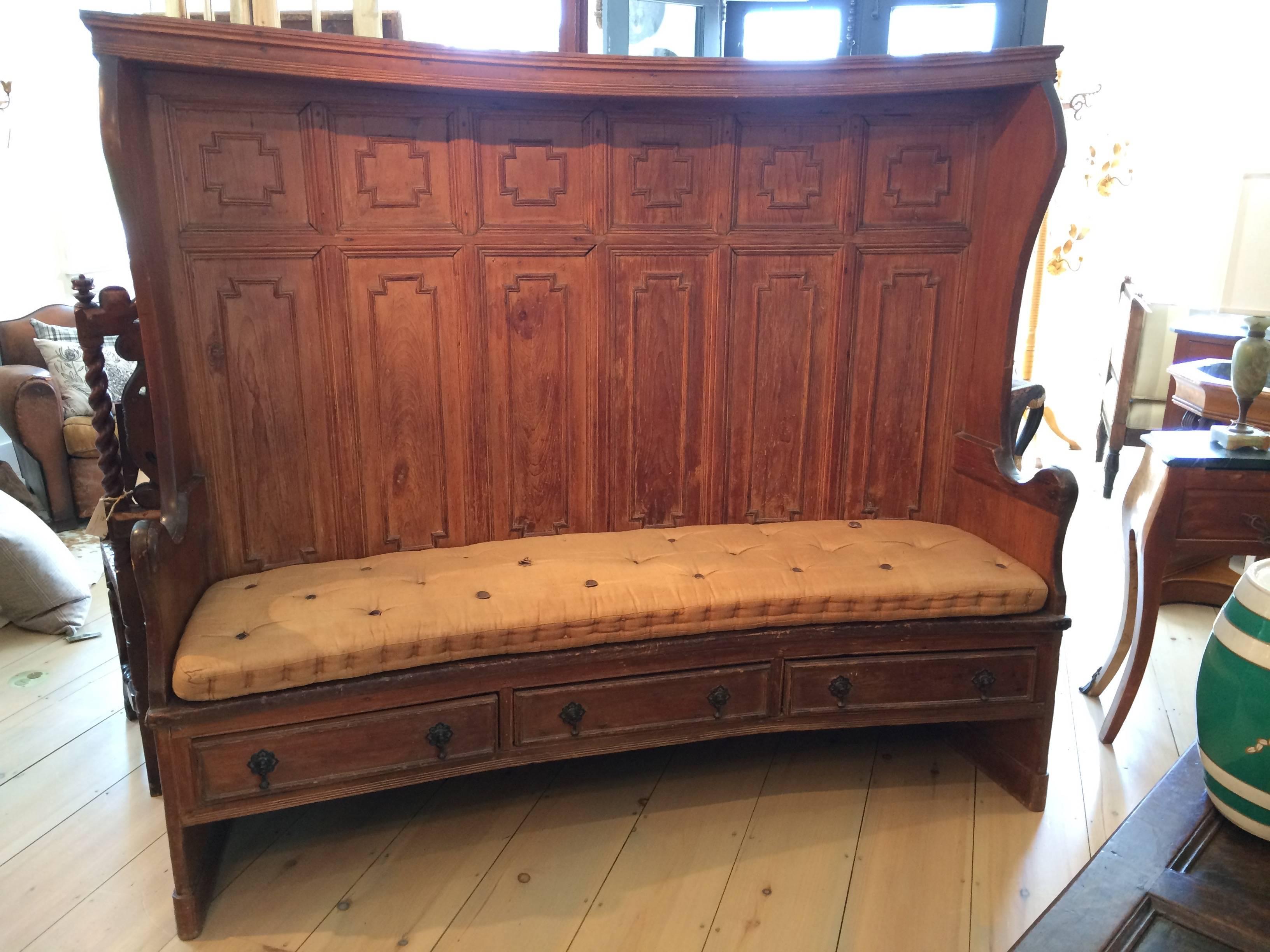 British Georgian Tavern settee with two-sided paneling and original leather-buttoned cushion. All-original, the tall back gently curves with the reverse fully paneled and the seat over drawers. Designed to protect the sitter from drafts, this can be