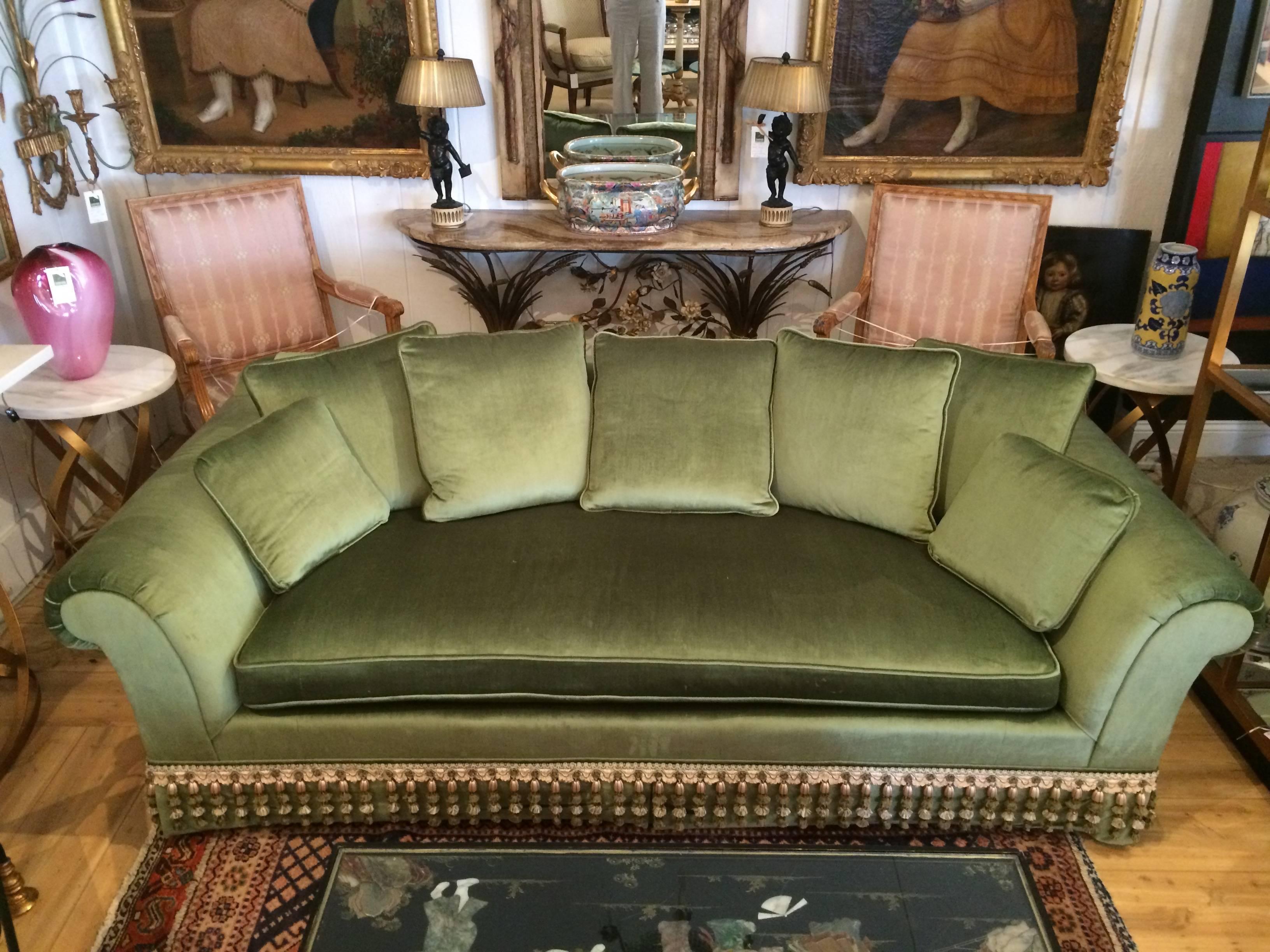 Sublime et luxueux canapé en velours, tapissé d'un doux velours vert sauge de France et garni d'une exquise frange bullion élaborée.  Le coussin est en mousse enveloppée de plumes.
Profondeur de l'assise 26,5