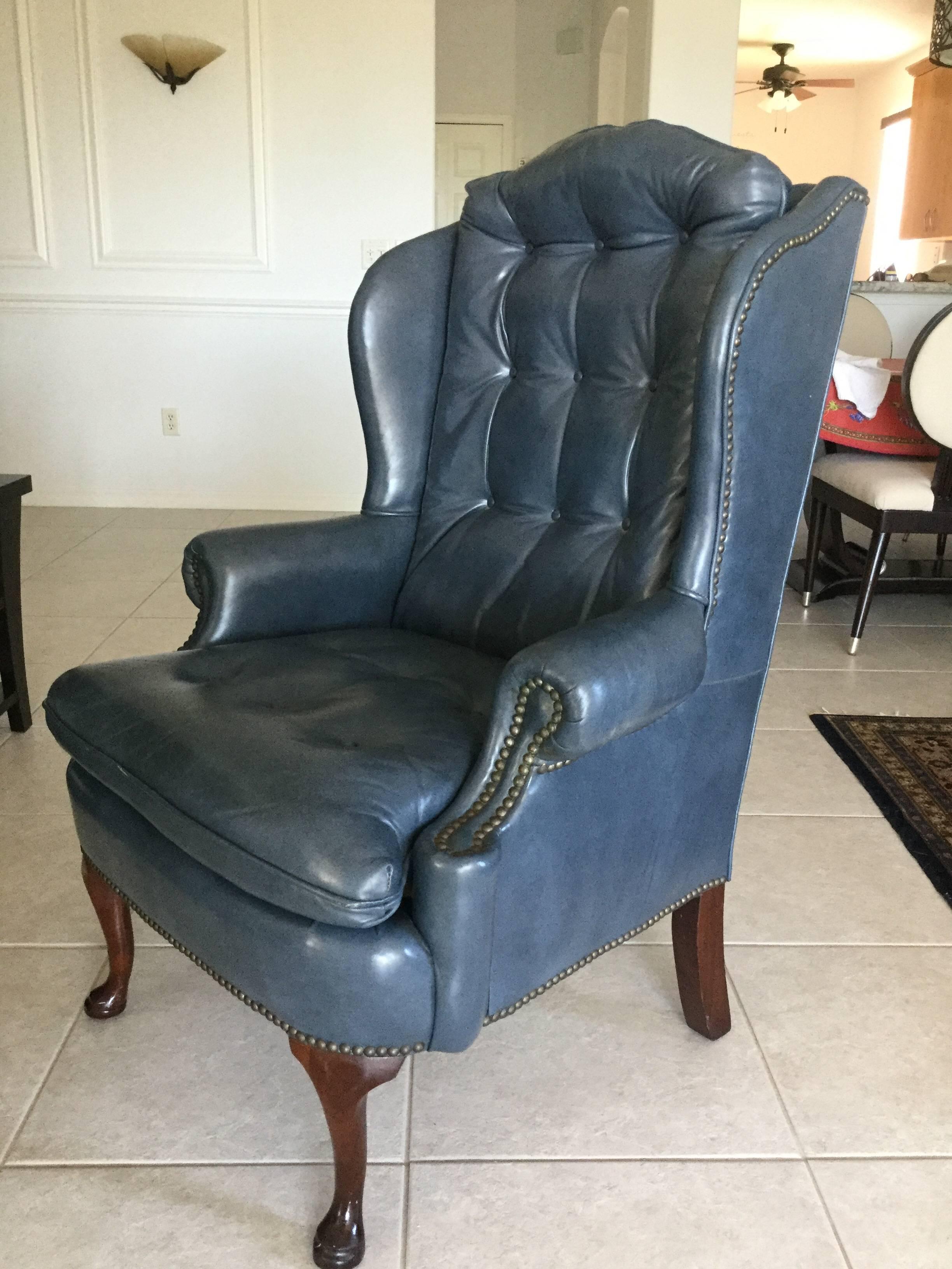 Handsome steel blue leather wingback chair having tufted seat and back cushion, Queen-Anne legs, brass nail heads, and rounded arm rests. Made by Classic Leather of Hickory, N.C. Mint condition.
Measure: Seat is 21 deep x 26.5 wide. Seat height is
