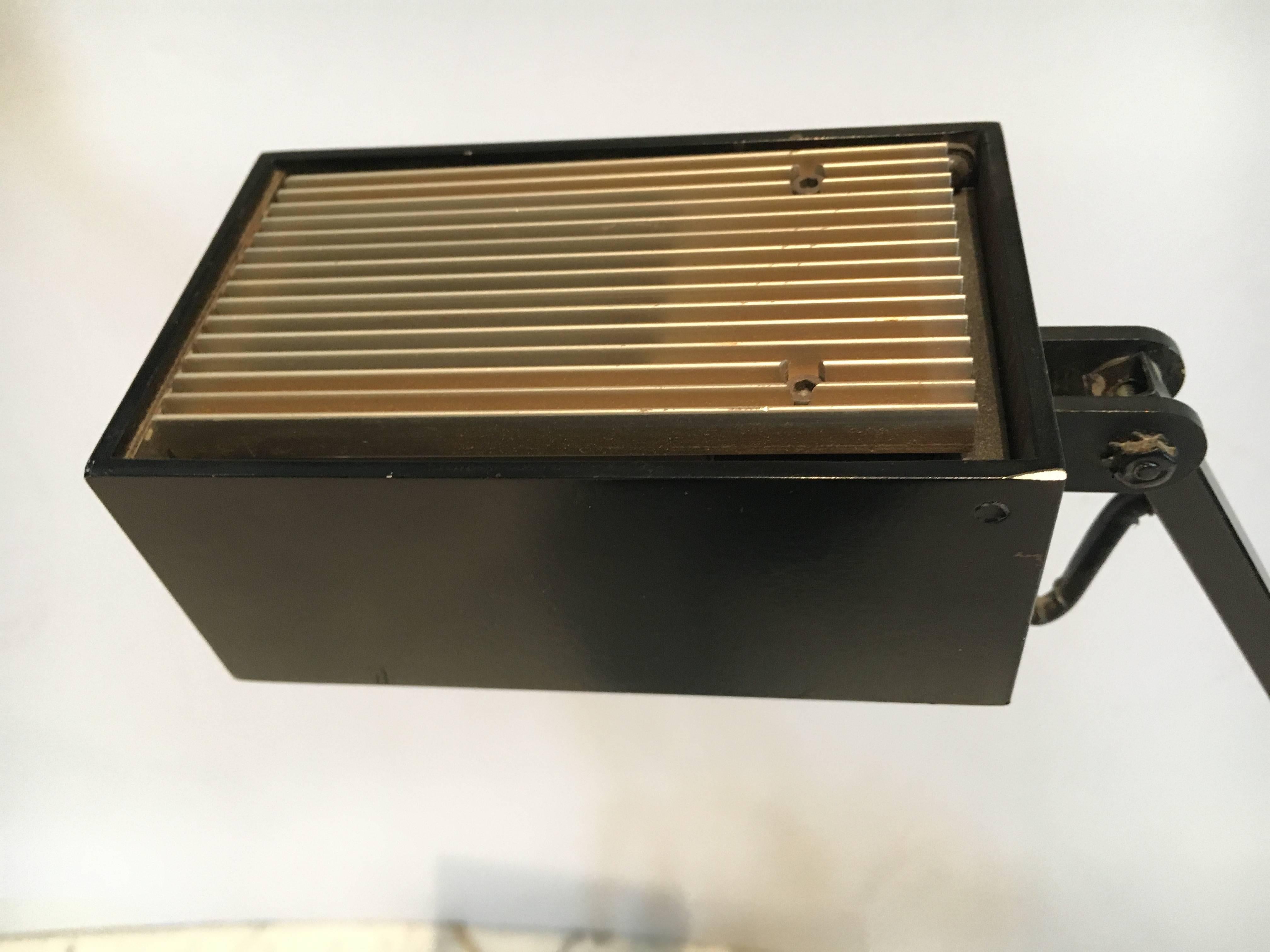 Classic midcentury cantilevered Tizio style desk lamp in black painted steel. The two counterweighted arms adjust for height of light from desk surface. The bulb side of lamp has a slanted piece of metal that prohibits glare from bulb. Lamp takes