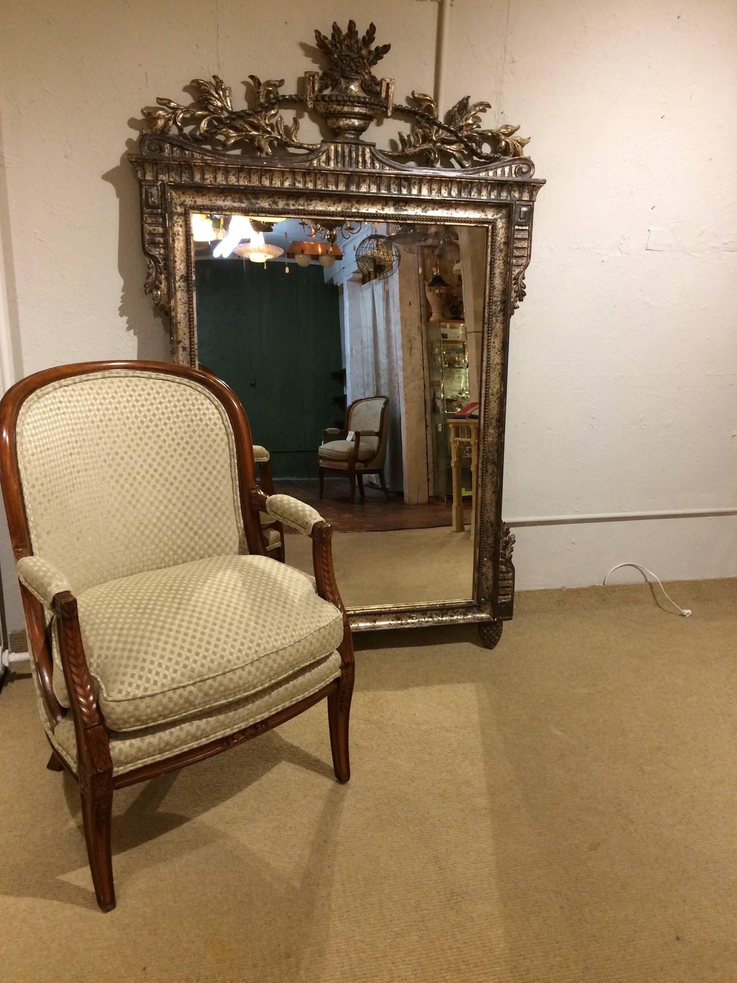 Magnificent and very large silver gilt neoclassical mirror having original aged mirror with subtle ghosting.