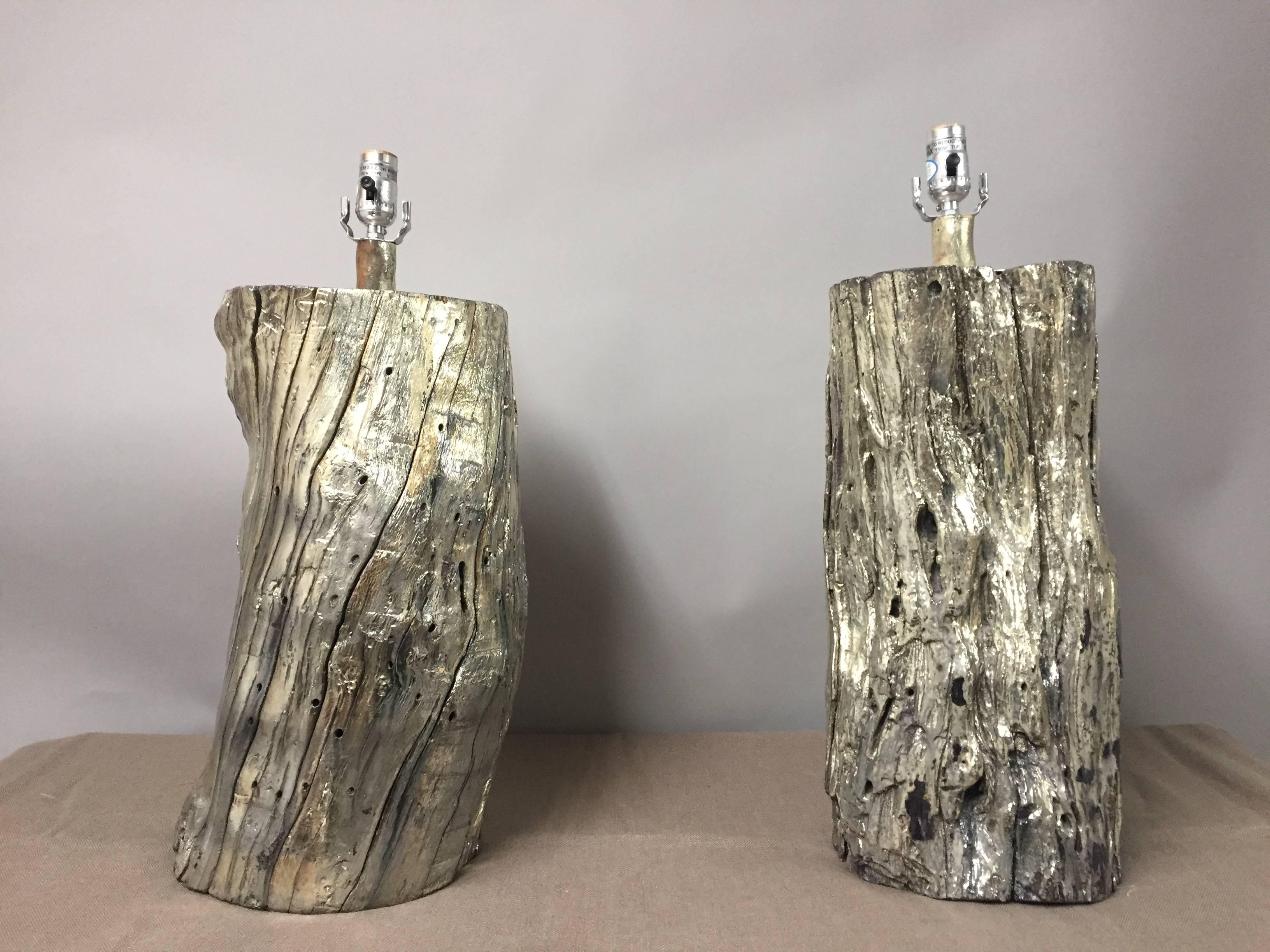 Two eye-catching table lamps having chunky organic log wood bases glamorized with silvered giltmetal and custom brown silk shades. By Tanner Kenzie.