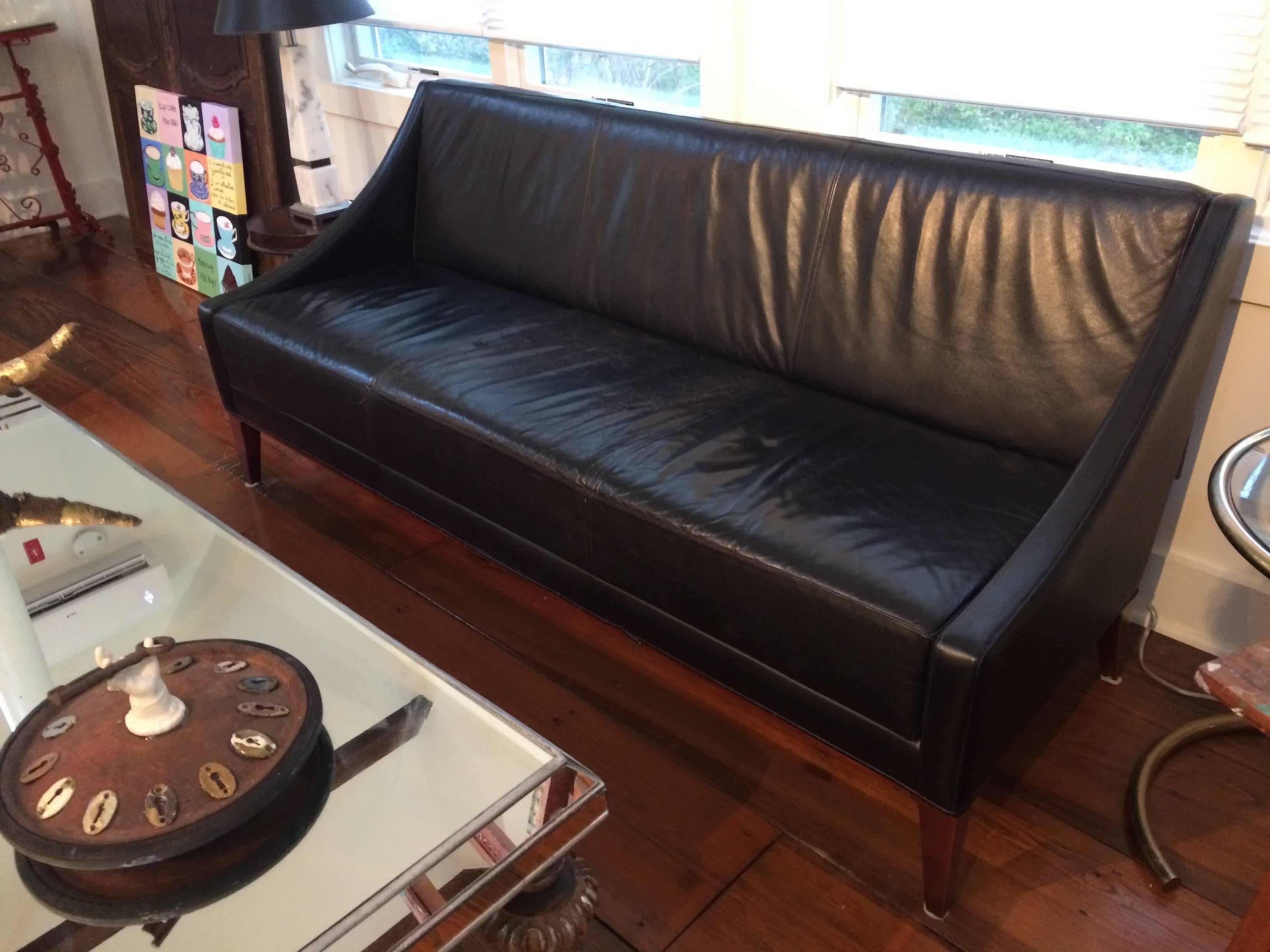 Sleek Mid-Century Modern slightly distressed black leather couch that came from a Men's Club in Philadelphia. Stylish, sexy and tailored.
