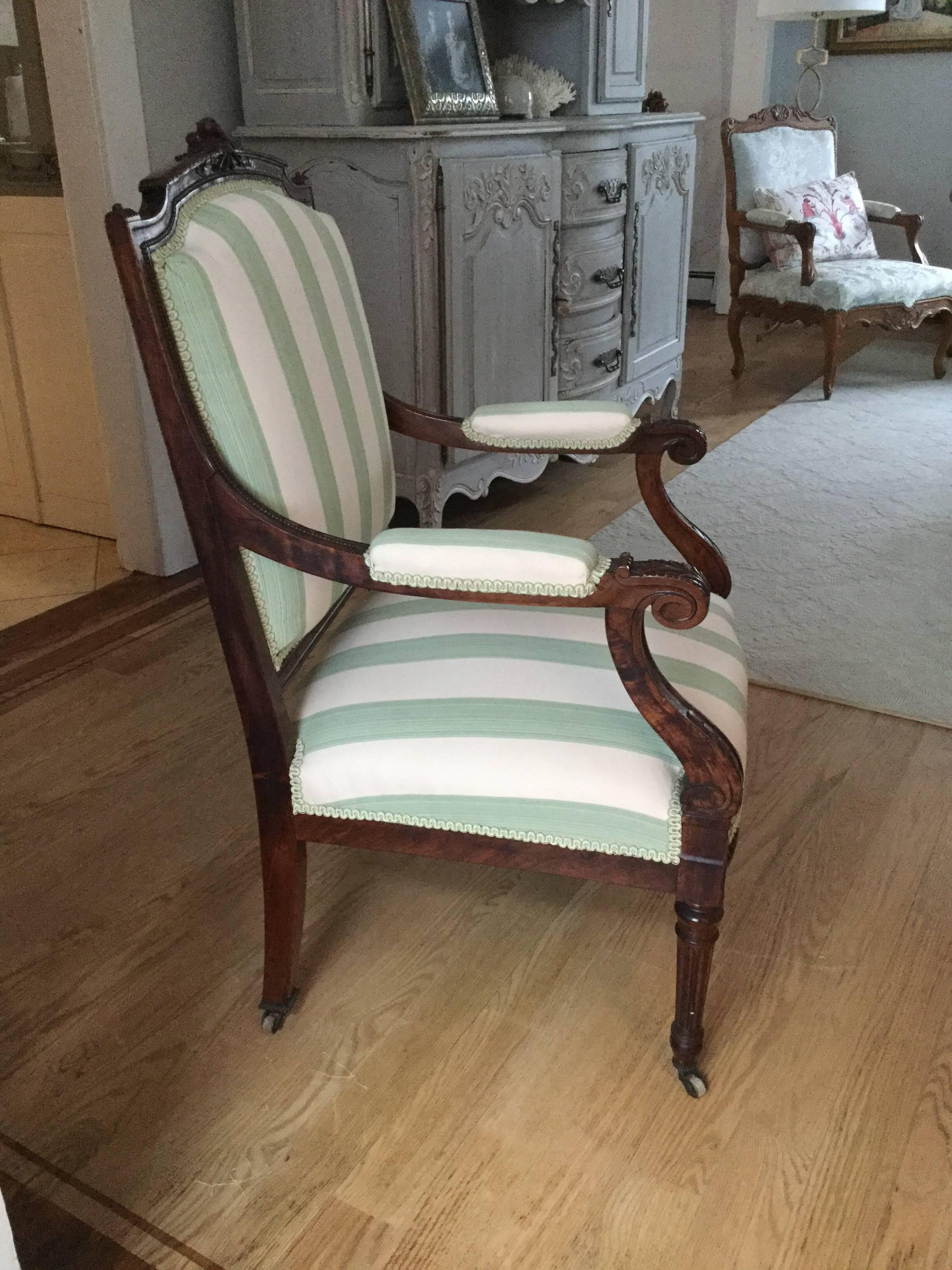 Stunning Louis XVI style armchair having a beautifully carved fruitwood frame with crest of small roses and acanthus leaves on the legs, upholstered in a wide green and white stripe with matching trim.

 