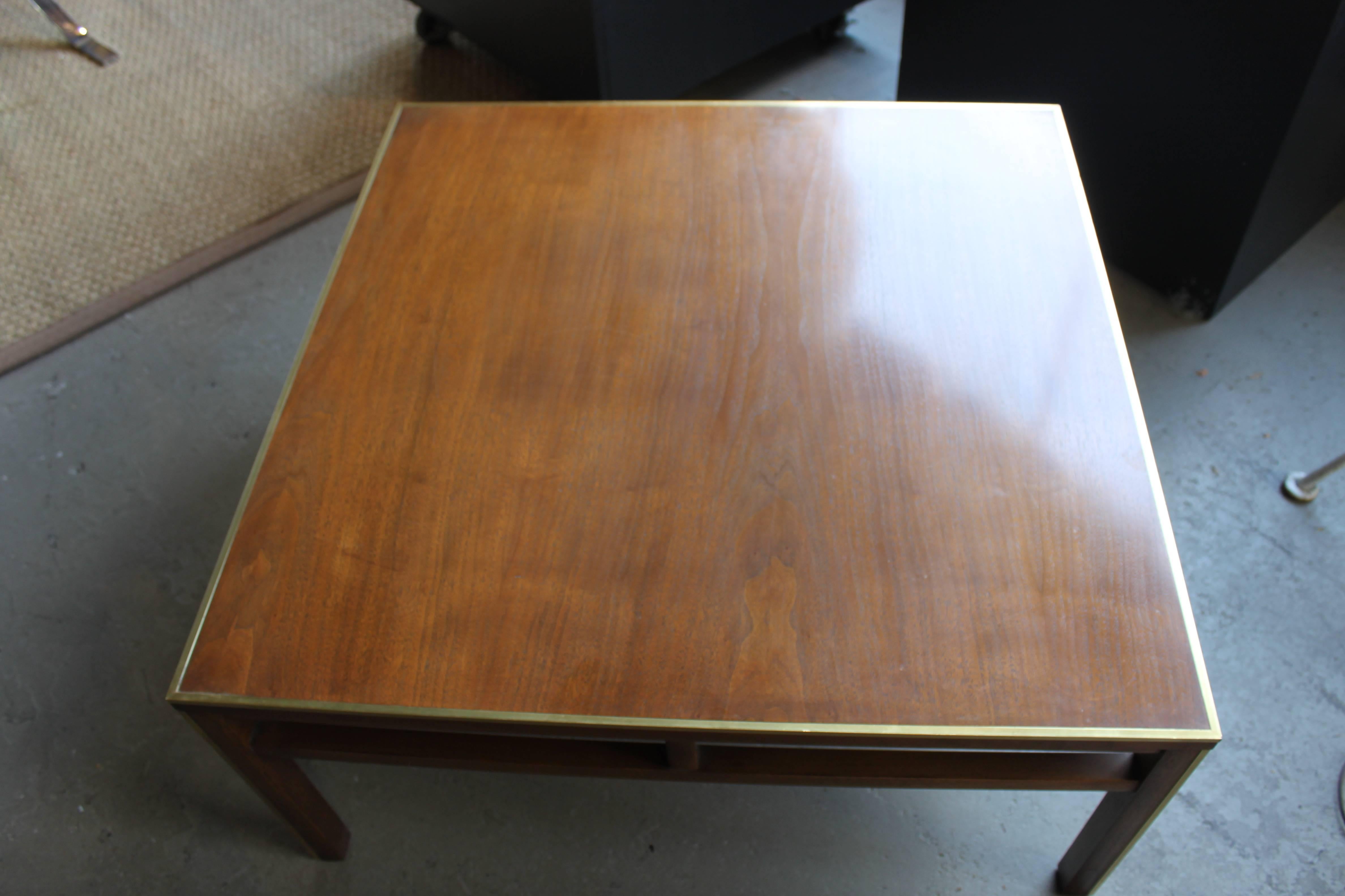 Brass trim coffee table in walnut by Lane. Minor issue with one small indentation on the brass otherwise the table is in very good shape.