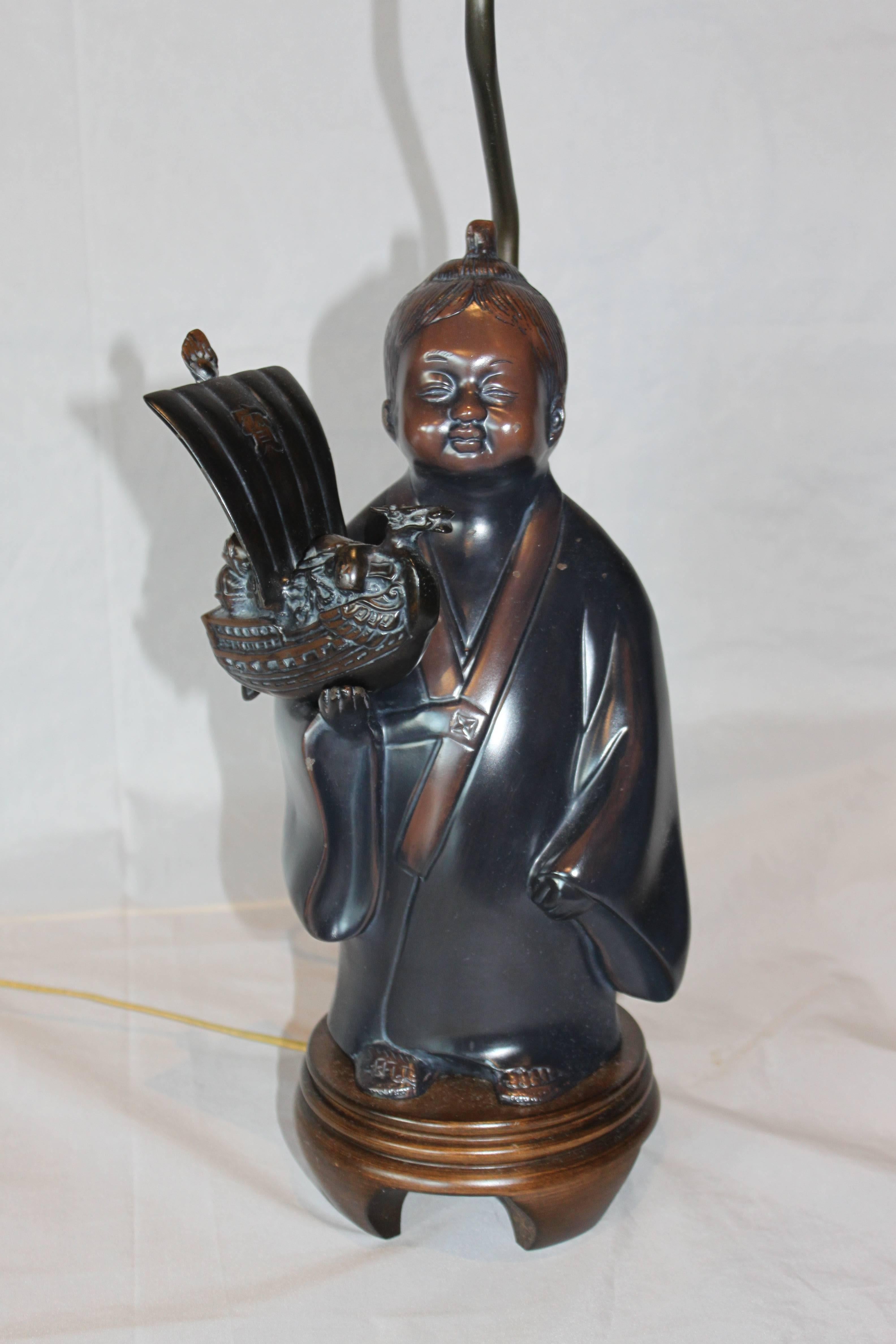 Frederick Cooper's bronze Asian boy lamp. Charming and sweet. The boy is holding a removable dragon boat. Measures: Height to top of statue is 15