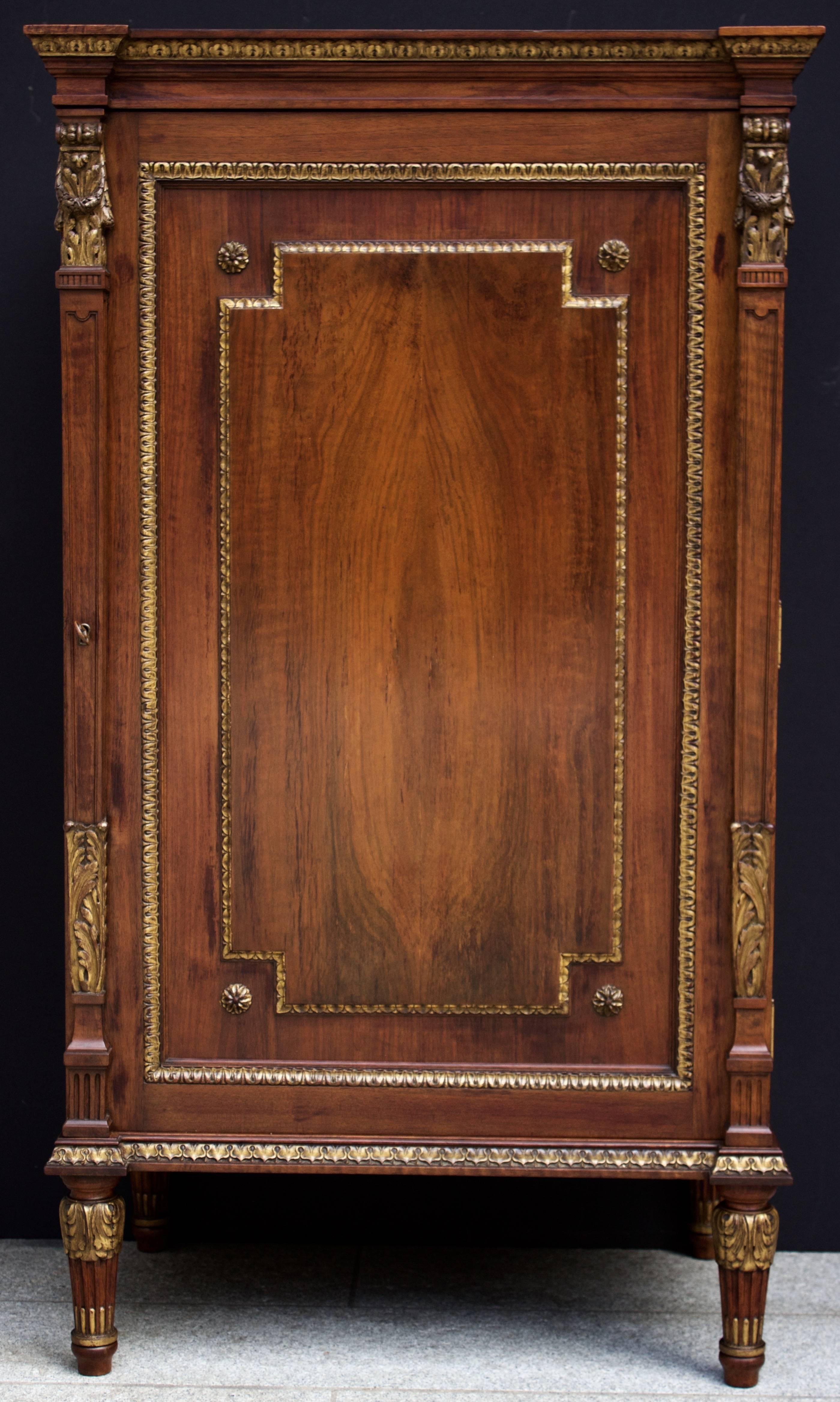 Wonderful style and exceptional quality for this cabinet in walnut adorned by carved and gilded wood decorations in front and on sides. It opens by one door -having its lock and key-revealing inside in the upper part six removable flecked maple