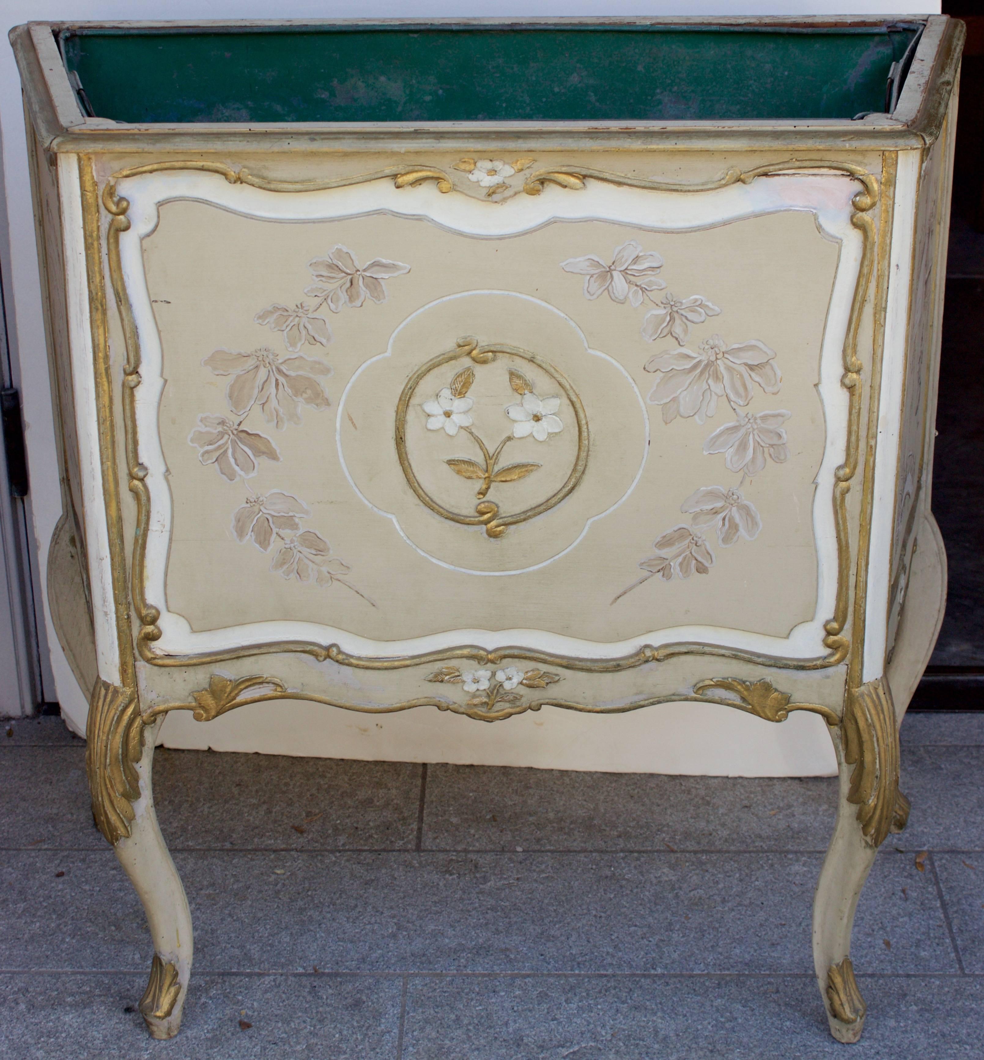 Rare large planters in carved and painted wood on three sides and resting on arched legs. Each side has a beige painted central panel surrounded by an ivory painted rechampi and gilded scrolled wooden baguettes decor. Chinoiseries decorated front