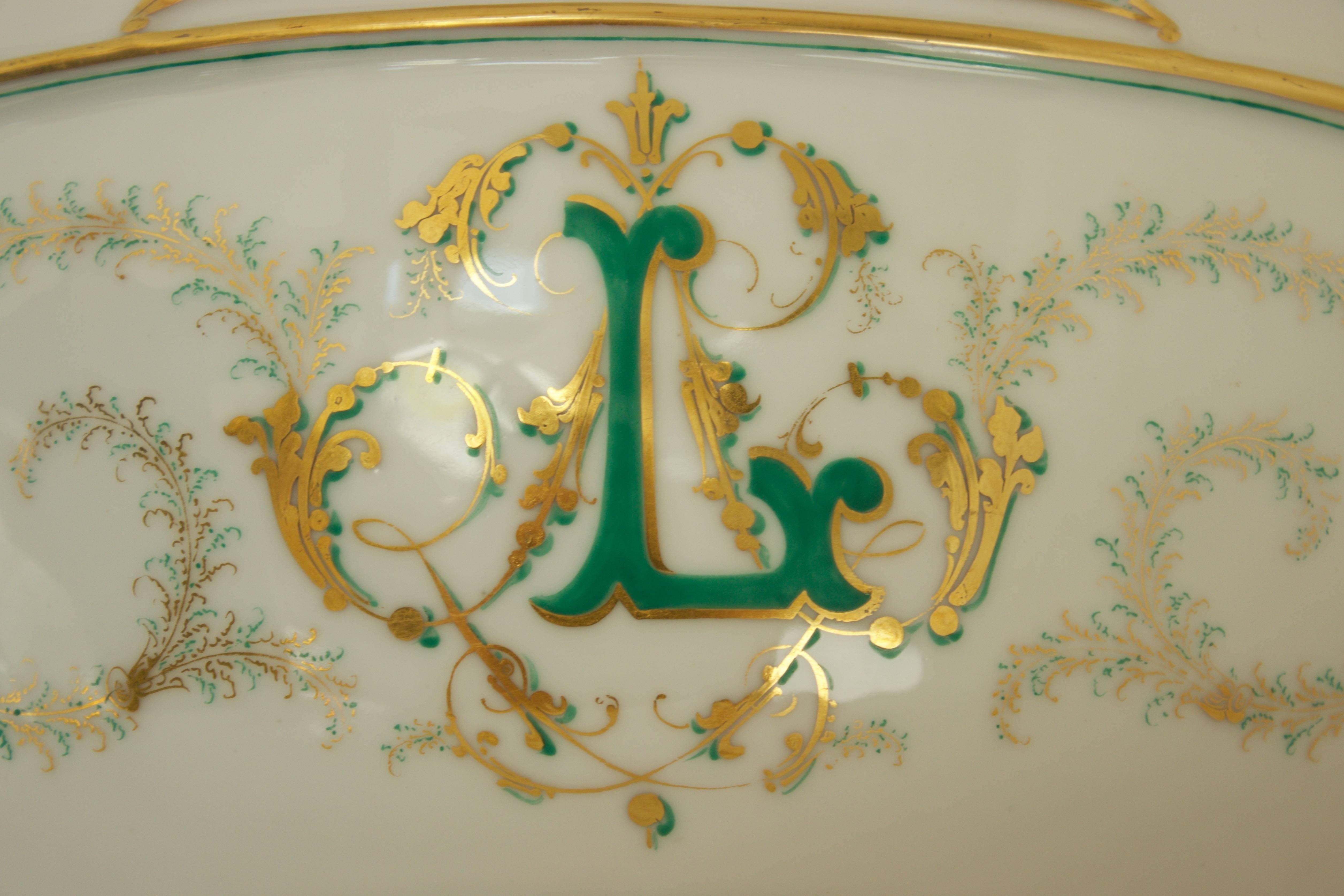 One-of-a-kind four footed center of table Jardiniere in Limoges porcelain with hand-painted scrolls in gold and greens colors. Oval shape with a sinuous top adorned by four stylized Fleur-de-Lis also present on the two handles. Double 24-carats gold
