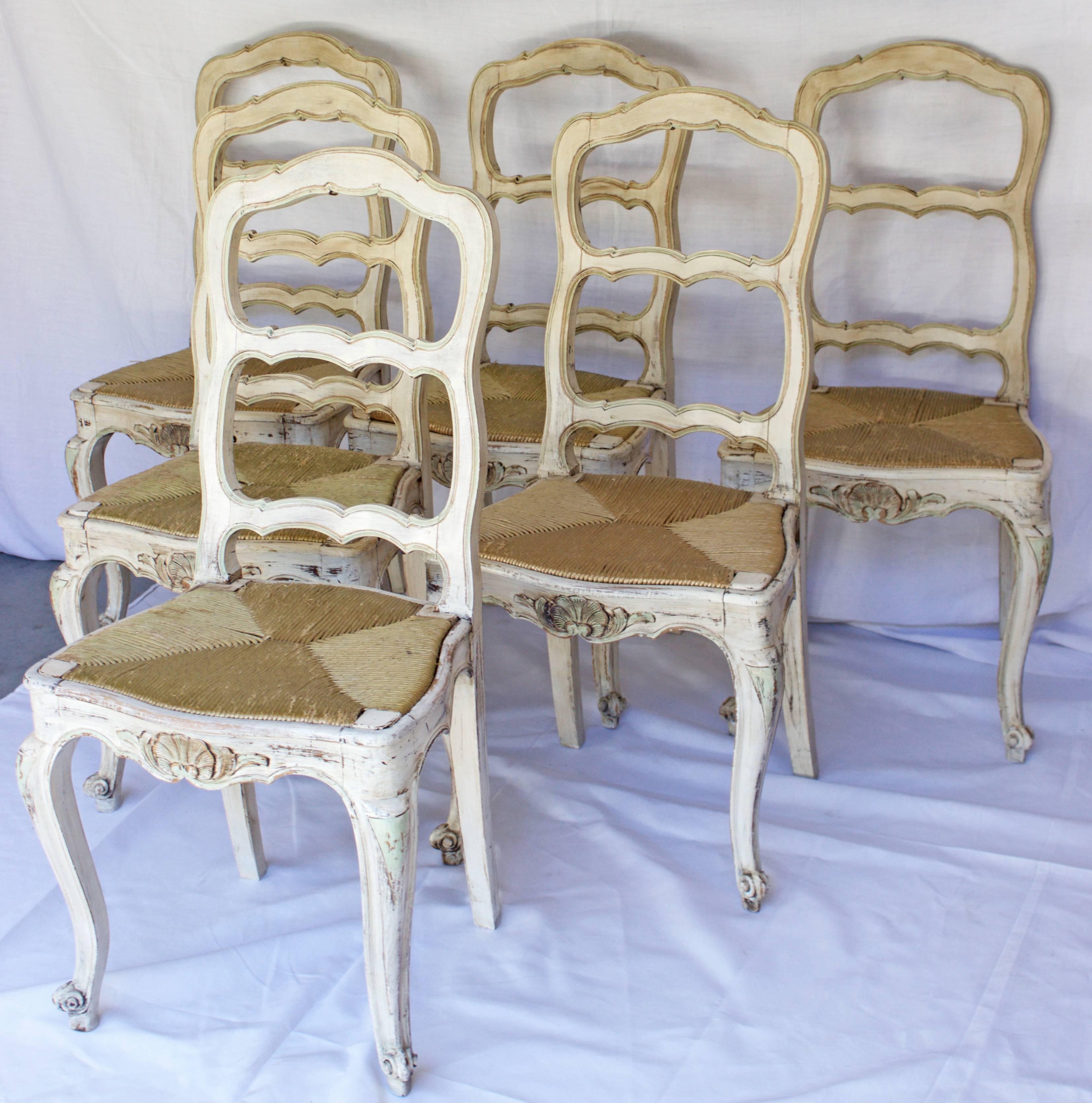 Beautiful set of Provencales chairs made in Louis XV style with high back rest  having each three scalloped crossbars, a removable rushseat on a wooden frame , two front feet in Console shape and two saber shaped backfeet.
The front crossbar shows