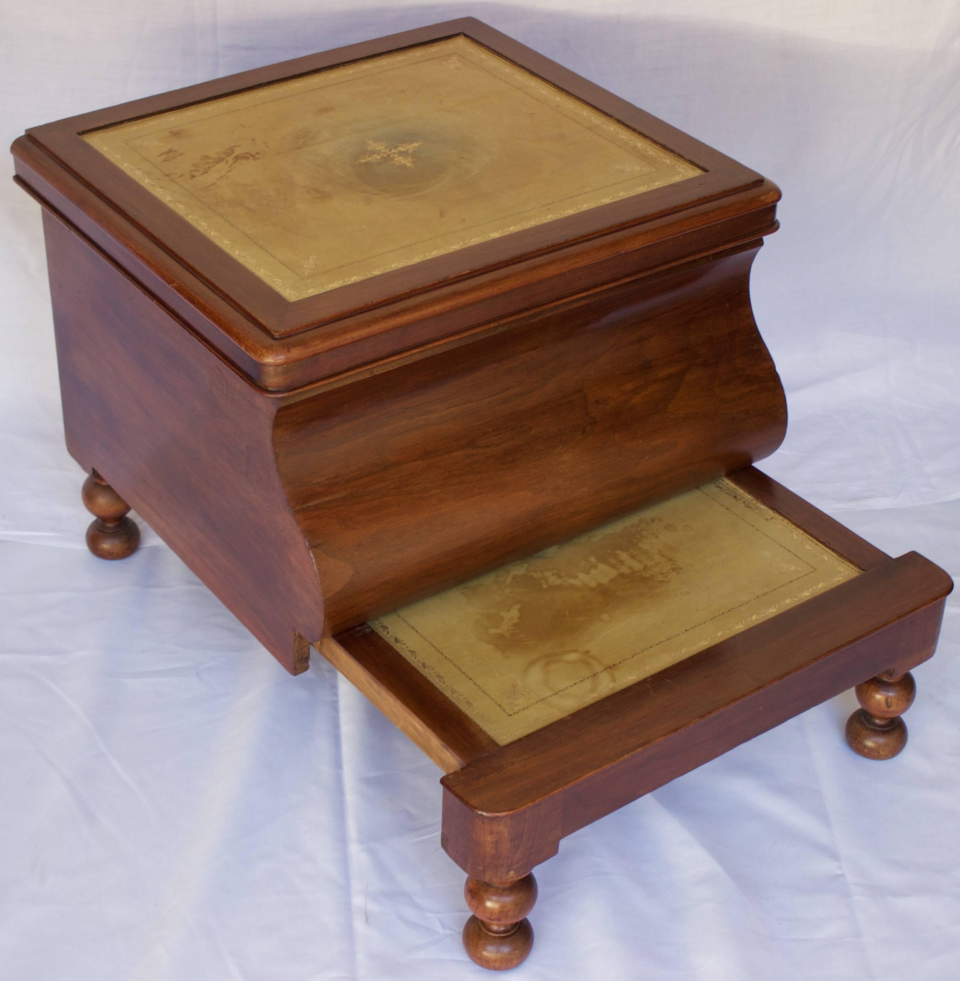 Interesting mahogany veneered Victorian era modified bedside commode with an arched front and four short turned feet. The upper part has been transformed into a chest with an hinged top. The retractable lower part can be used now as a foot stool.