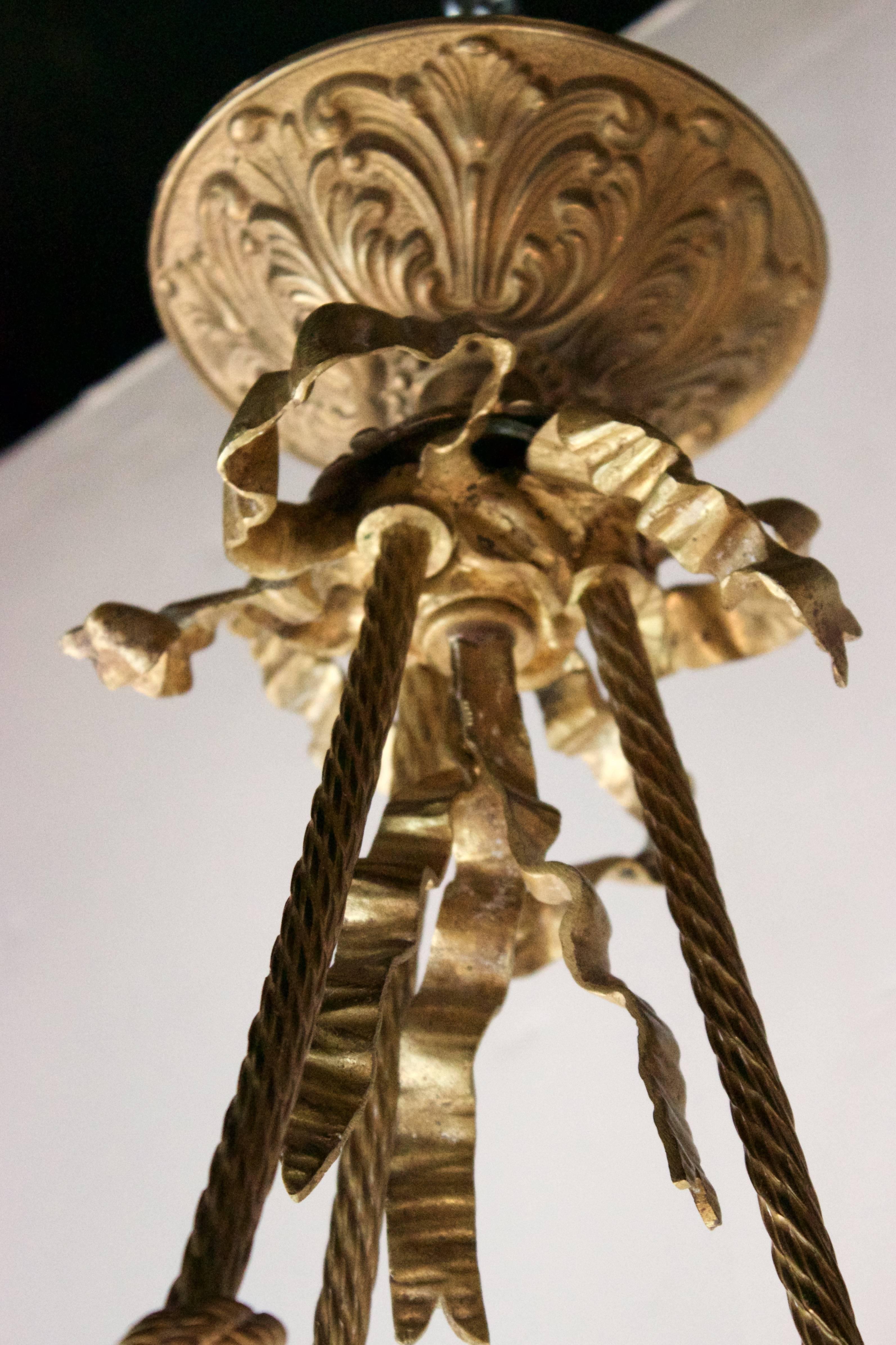 Rare Art Nouveau period pendant with three gilded bronze arms and four lights. Rose form glass shades for the three arms and a glass flambeau at top.