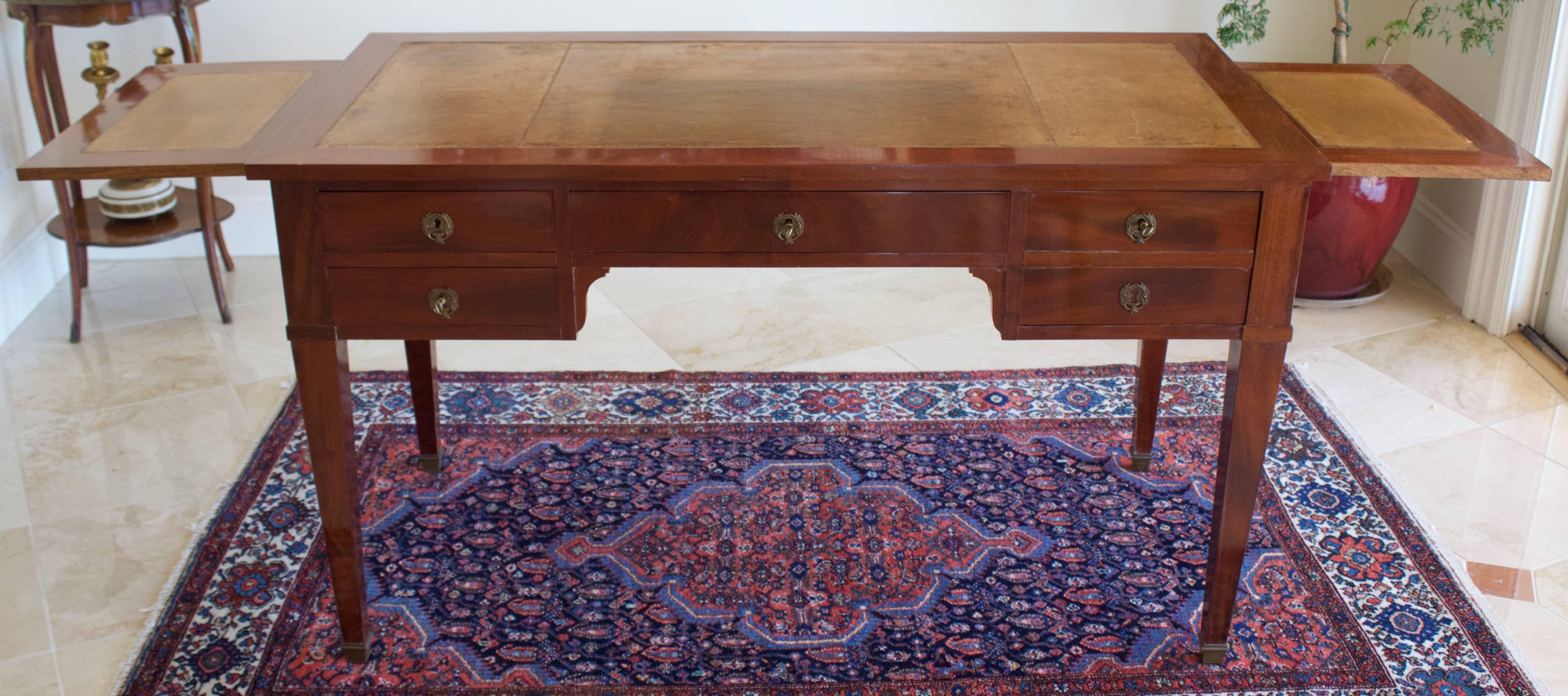 Sober but very elegant lines for this early 19th century made double-faced bureau plat in mahogany and mahogany veneer on oak in the true Directoire style. Comes with a long central drawer flanked by two small drawers on one side and a deep drawer