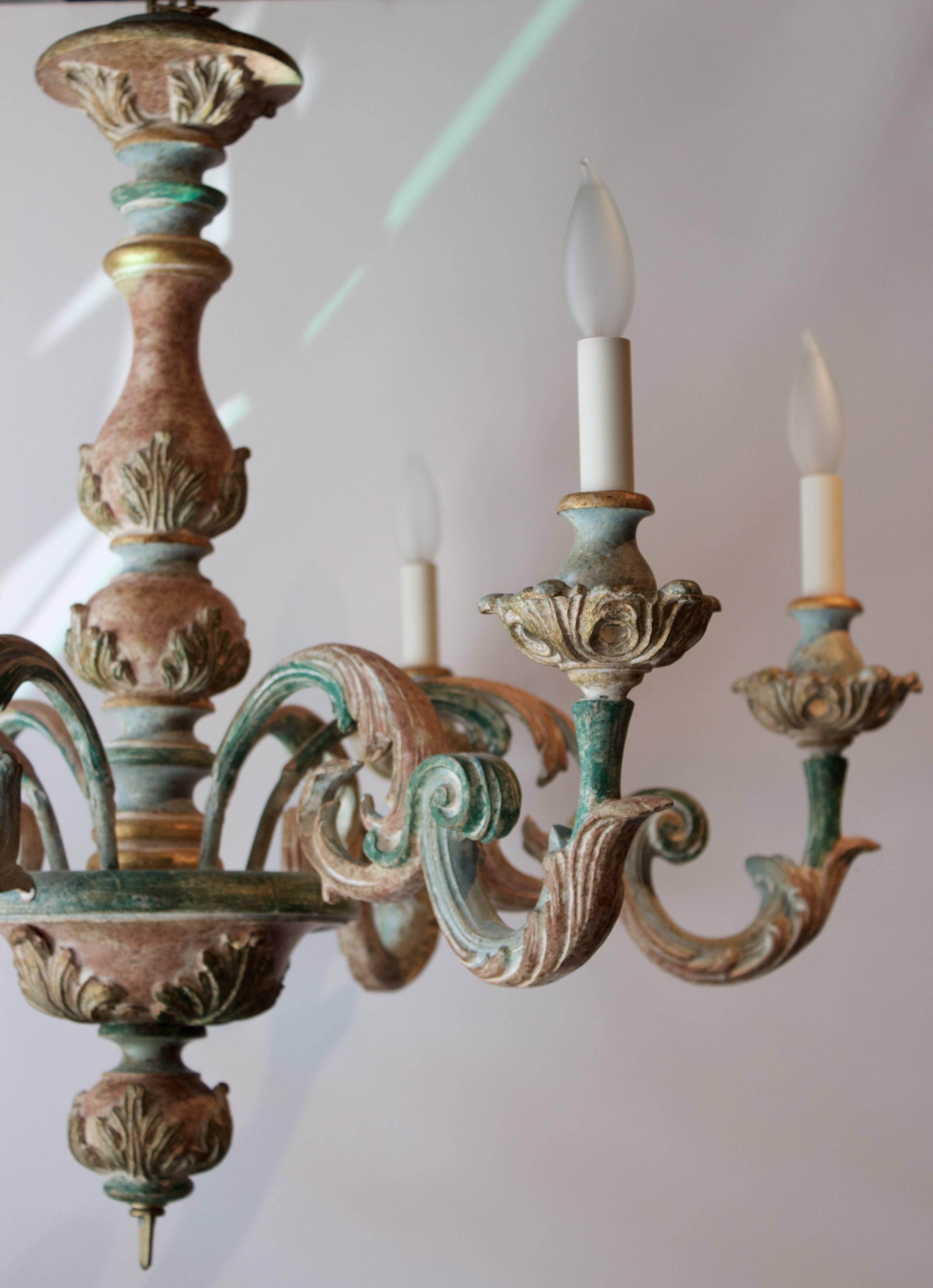 Beautiful Italian Rococo revival hand-carved and painted wooden chandelier. Beautiful scrolls of acanthus leaves are the motif of this Italian chandelier. Hand-painted delicately with gilt accents. Finial could support a tassel or be replaced by a