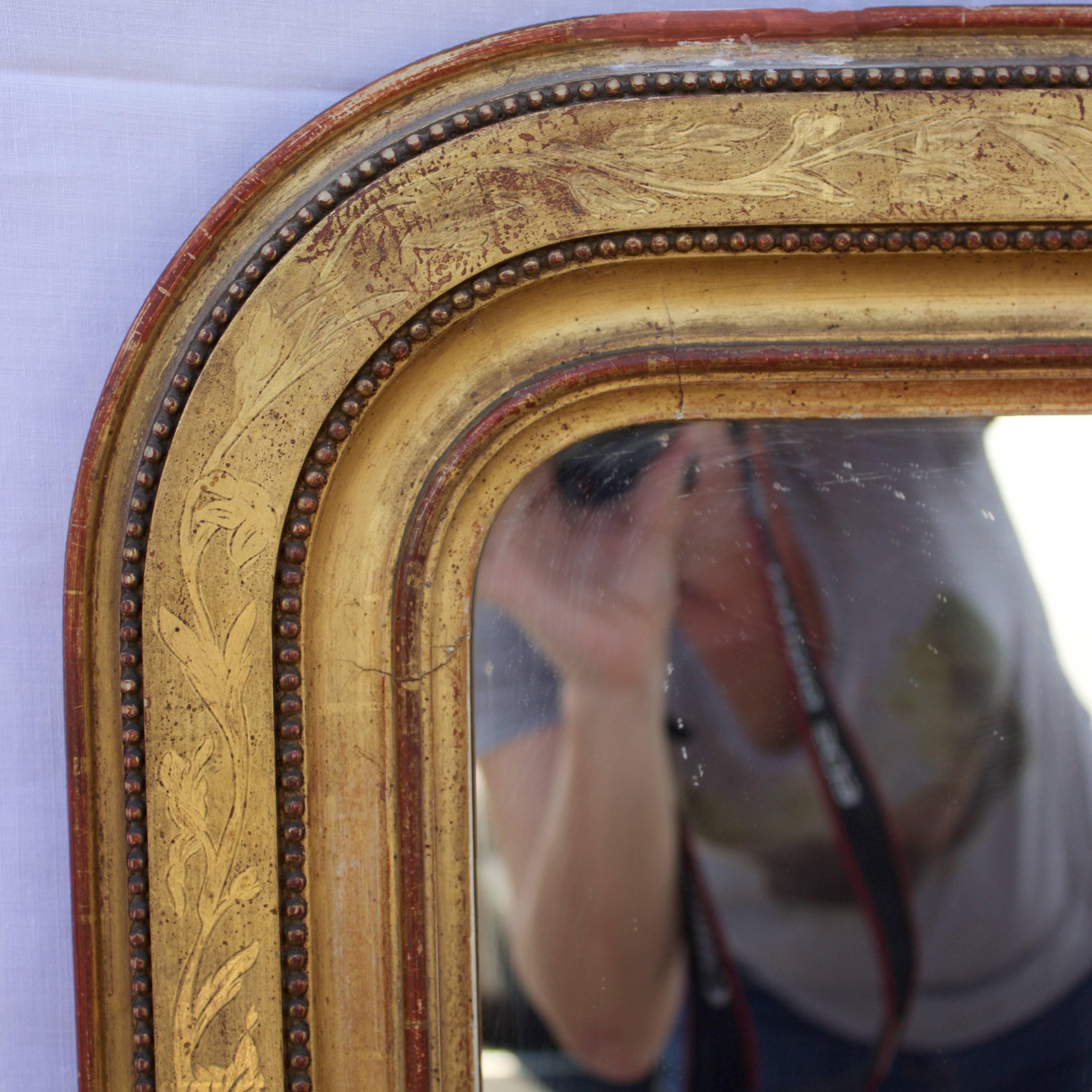 Interesting design and fine quality mirror having a flat water gilded surface covered by foliage made by a technique called 