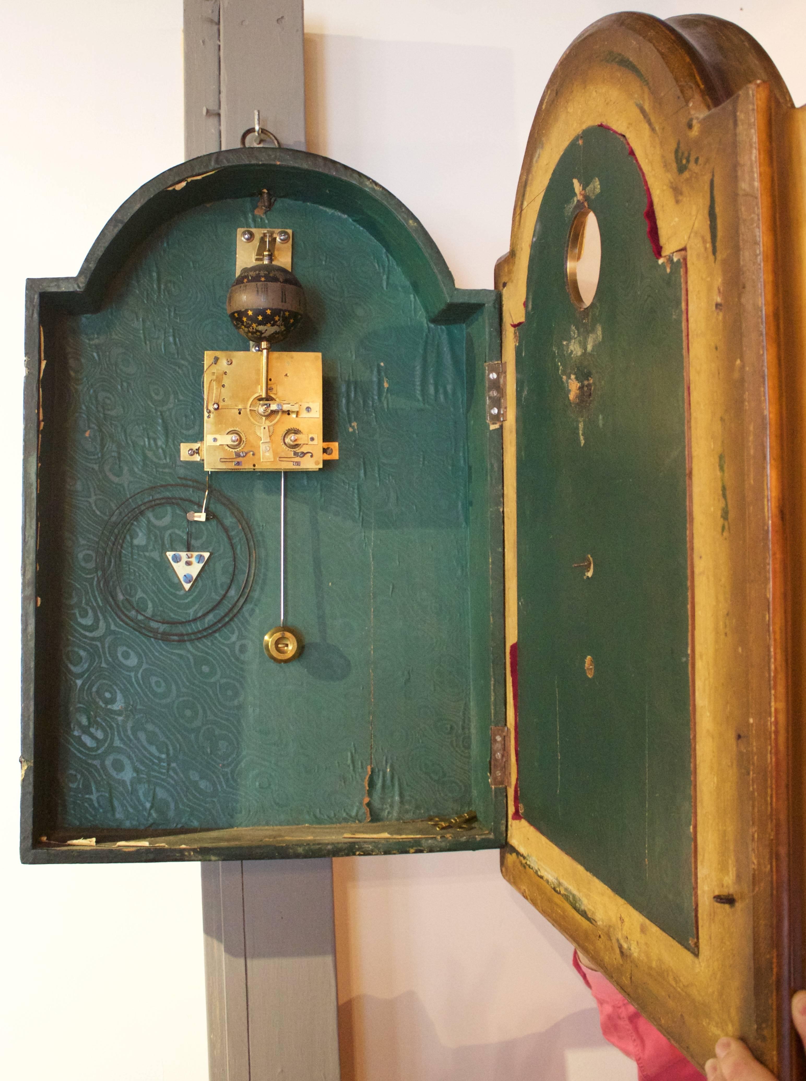 Unusual striking clock with a magnificent gilded wood frame having a glass front enclosing and a bronze doré Christ on a wooden cross. The time is given by Roman numeral on a midnight blue lacquered globe sprinkled with gilded stars above a pair of