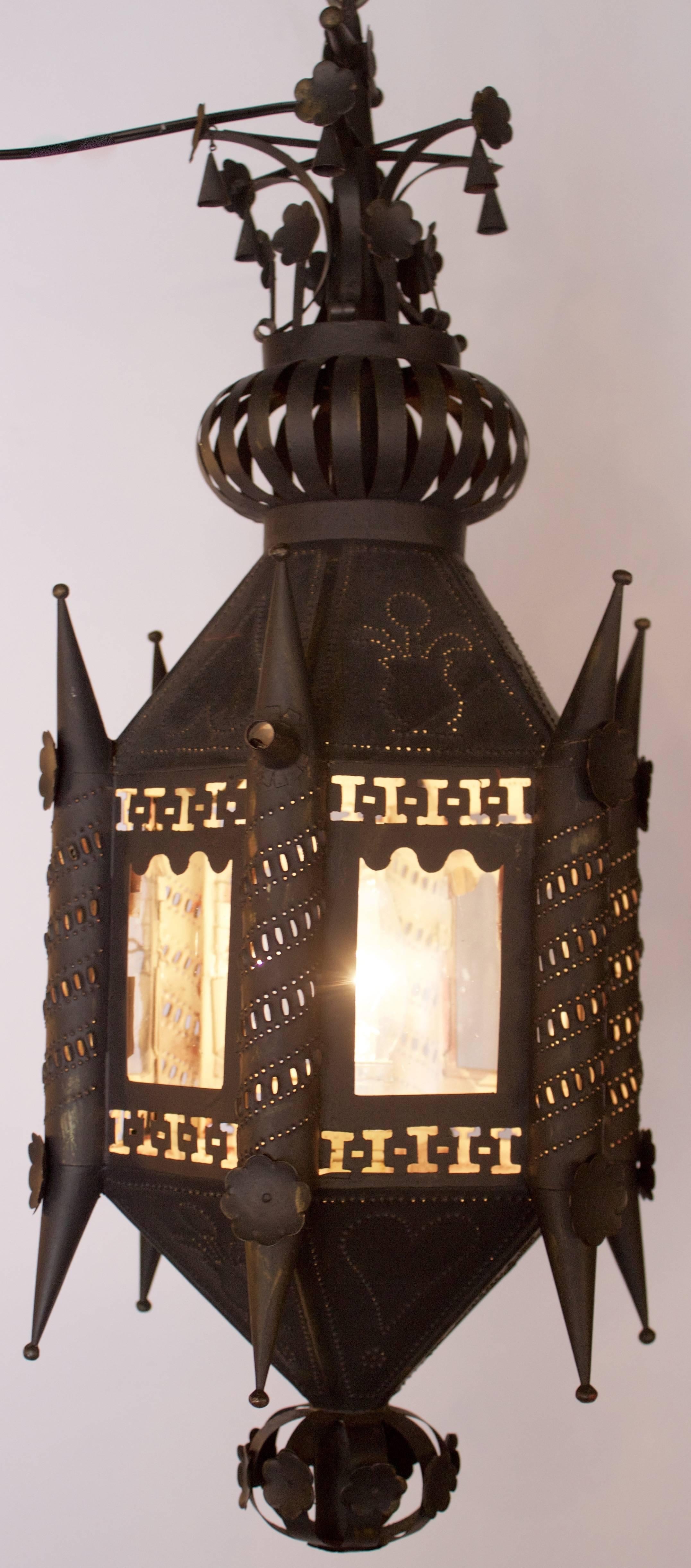 Pair of hall lanterns with pierced and punchwork decor in black painted tin and in hexagonal shape, each side having a glass window. They were fitted with candles and now have been electrified with USA std.