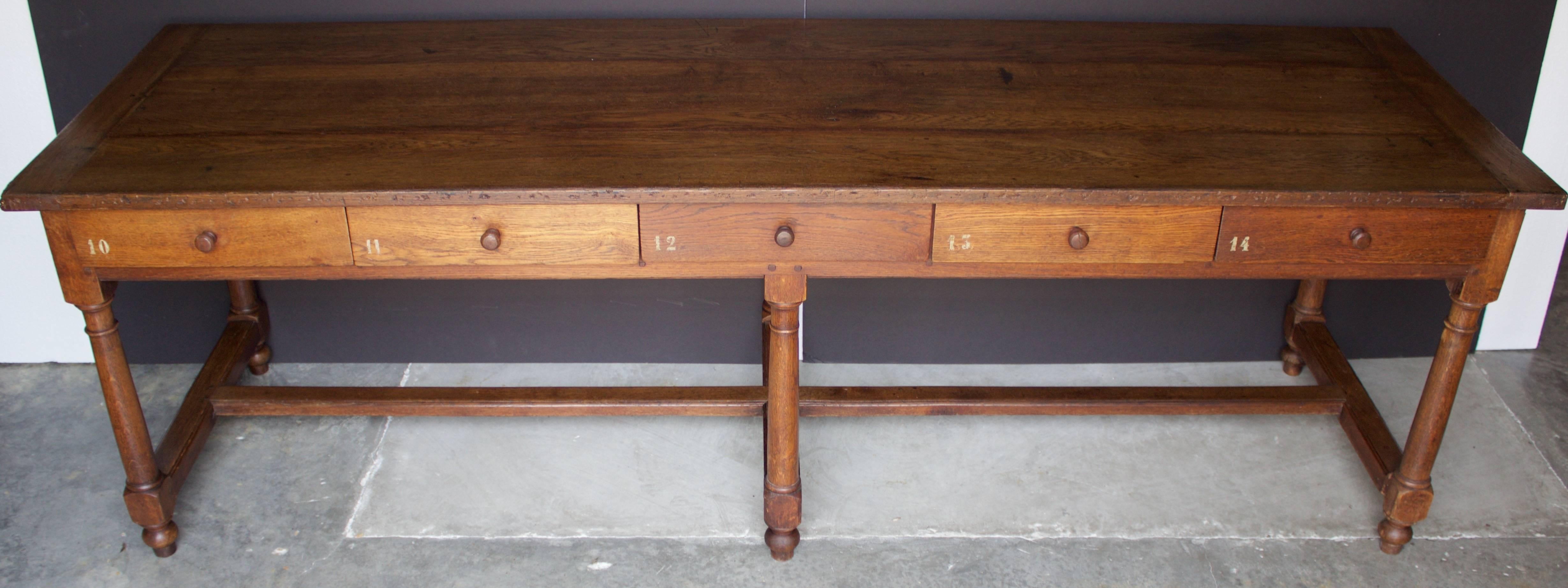 Rare oak table with 10 numbered drawers on the inside with roman numerals carved and on the drawer fronts more recently stenciled (5 drawers on each side) coming from a religious communauty next to the city of Lille. It rests on six beautifully