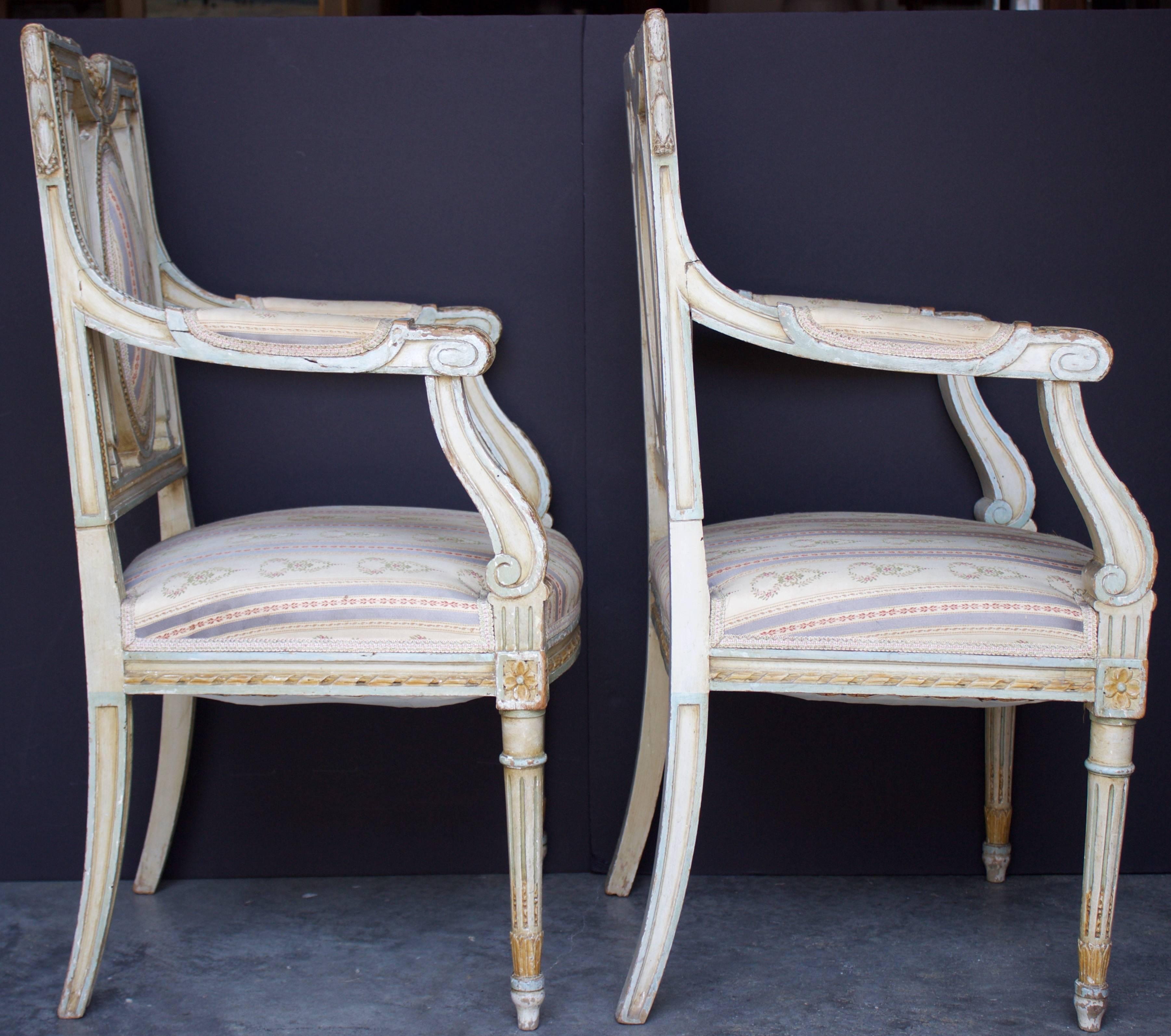 A Delightful pair of Period Louis XVI Armchairs with an incredibly elegant silhouette and variegated ornamentation on their backrest, posts, armrests and legs.
Square backed and decorated by handmade beads and Olive Laurel all around, concave top