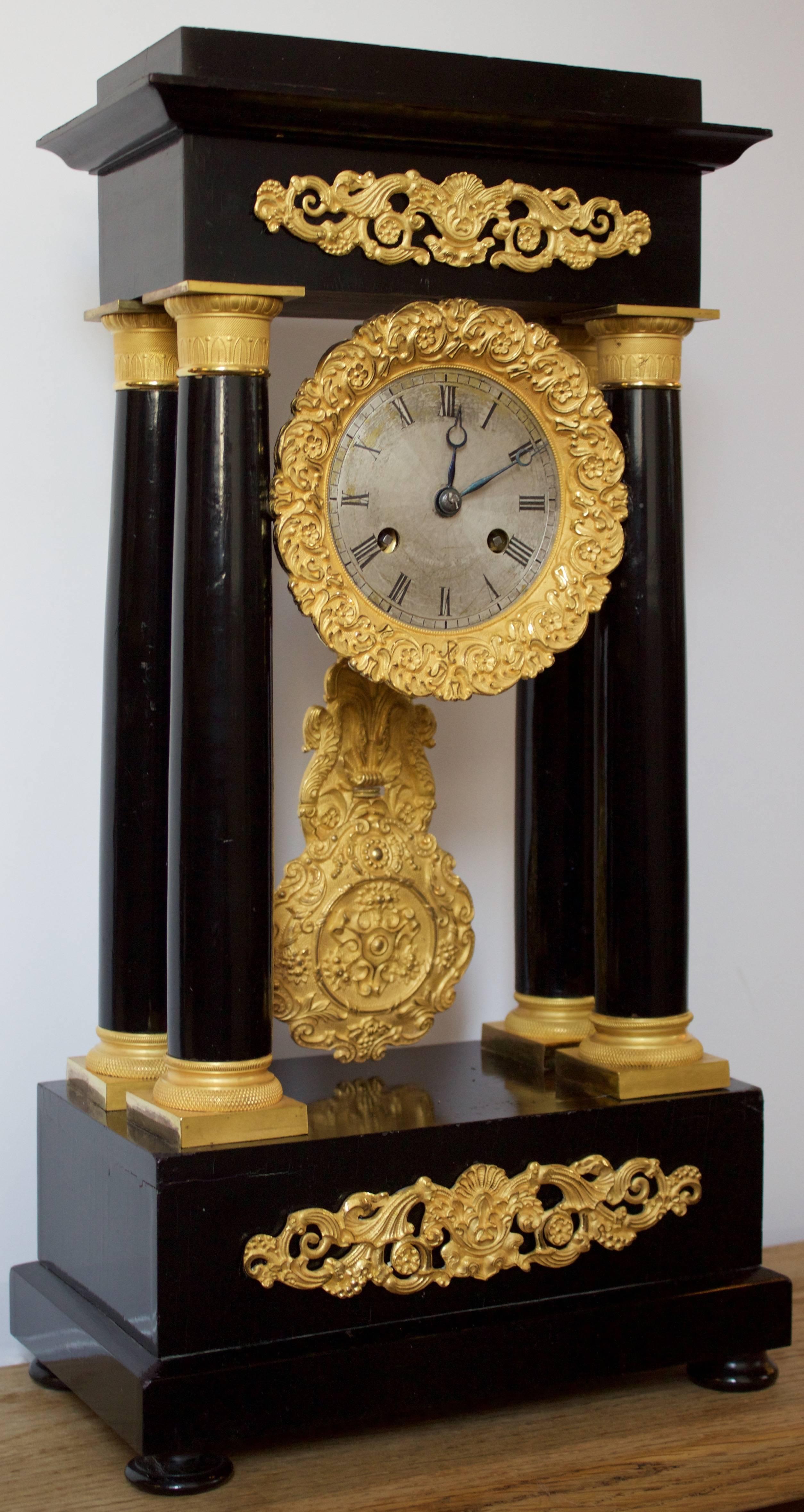 Absolutely magnificent chased and ormolu coated bronzes on top and bottom friezes, around the dial and columns mounts. Dial is a patinated white metal with black Roman numerals.
Gorgeous original pendulum with its small roller to adjust the clock