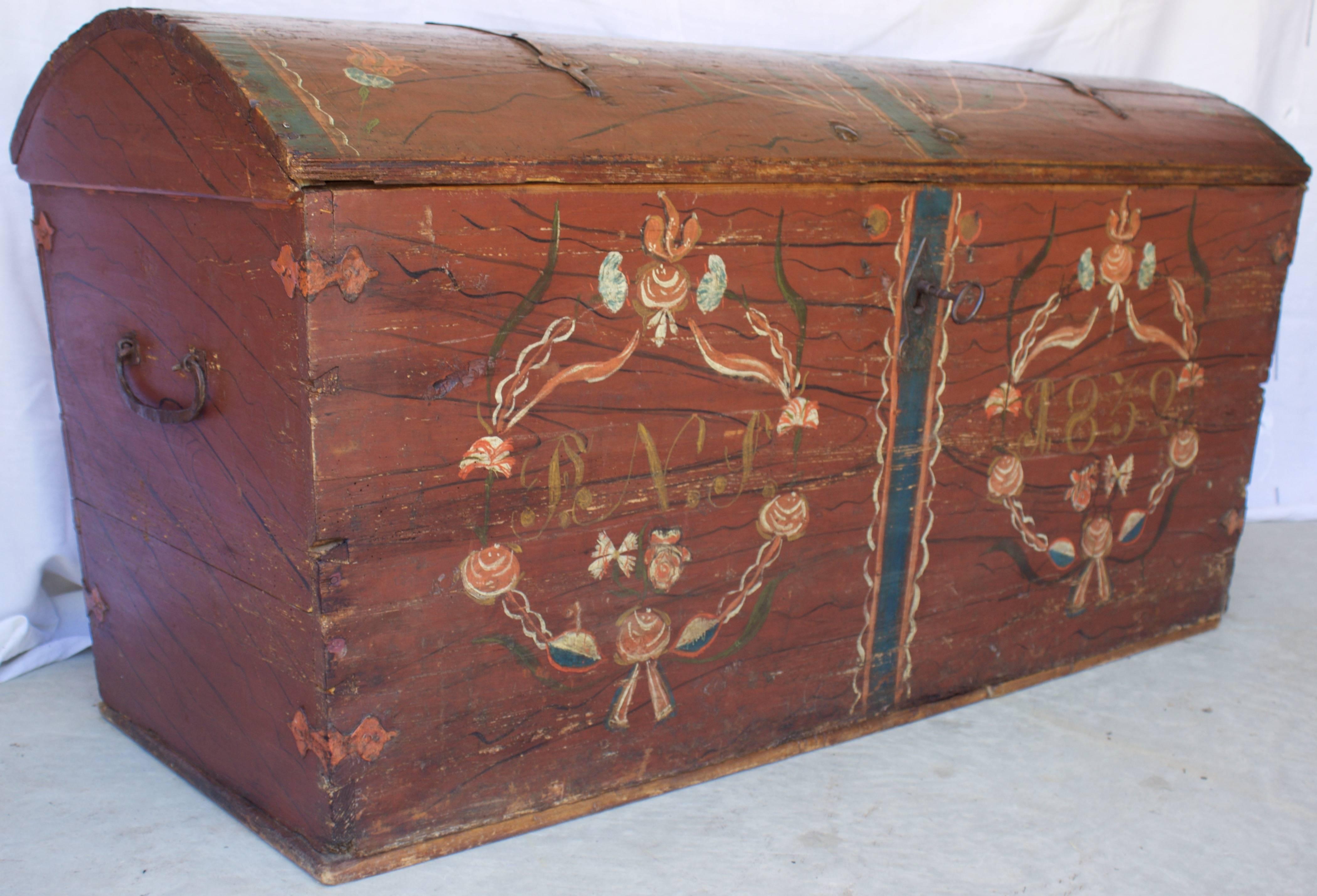 Charming and authentic Alsatian wedding chest in pine and hand-painted in a soft red background with a decor in front of two stylized guirlands of flowers circling the wedding date 