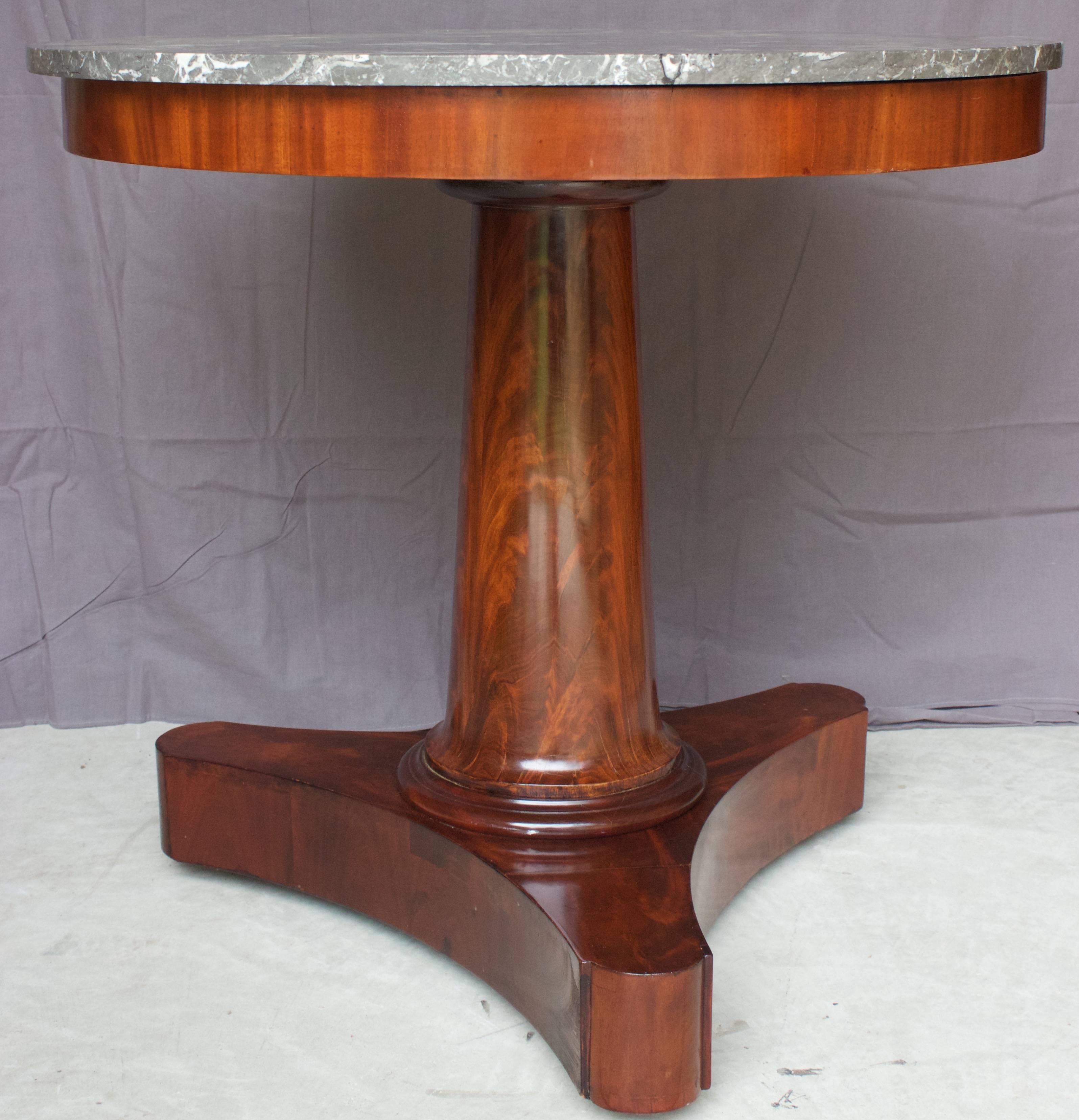 A very fine French Empire guéridon with its marble top on a mahogany veneered oak support above a cylindrical column resting on a tripod base with its original castors. French polished flamed mahogany on oak and grey Sainte-Anne marble top.
Very