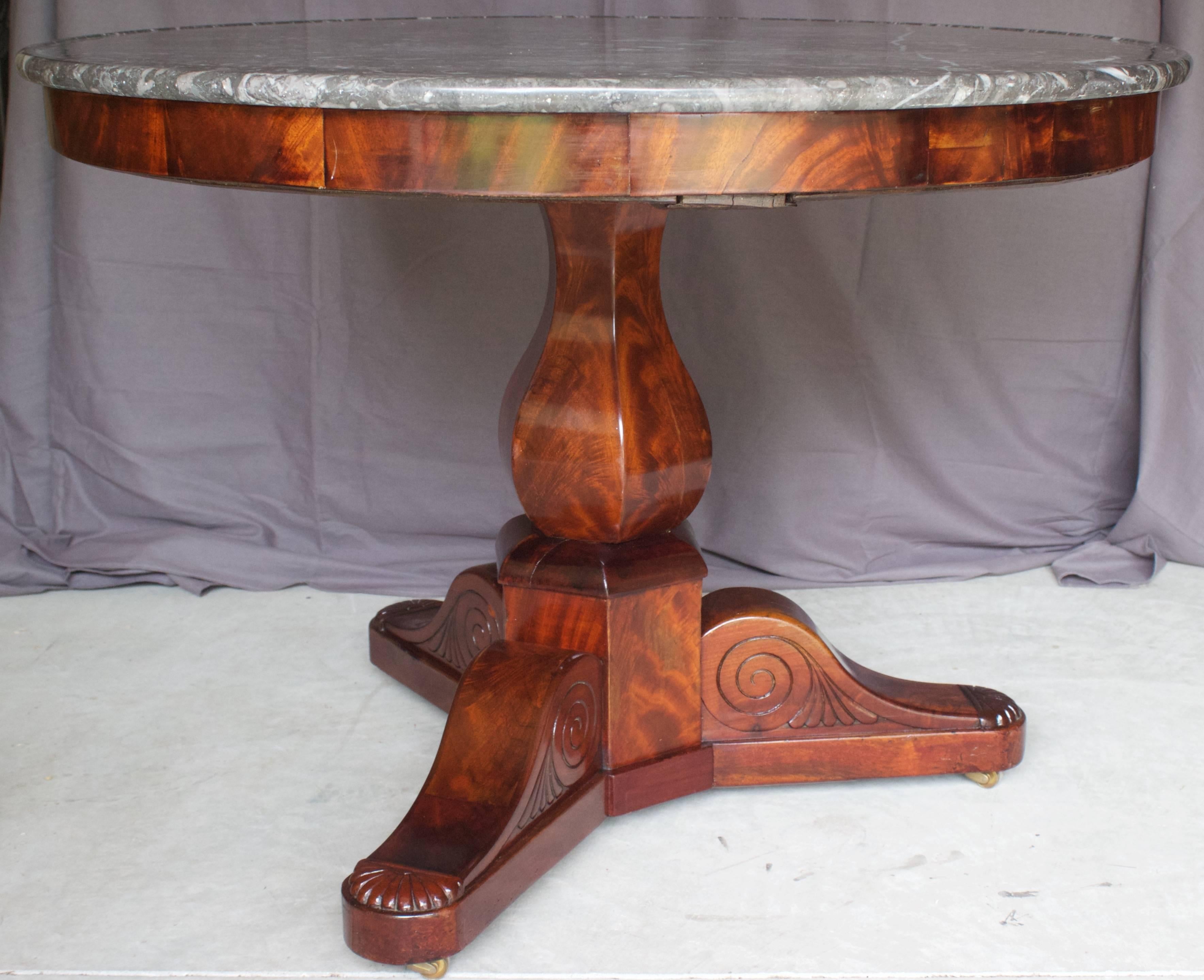 Nice mahogany gueridon made during the Restauration period (1815-1830) with a six sided baluster shaft supported by smoothed tripod feet on original castors. The top is a Sainte-Anne grey marble “à cuvette”.
Very good condition.