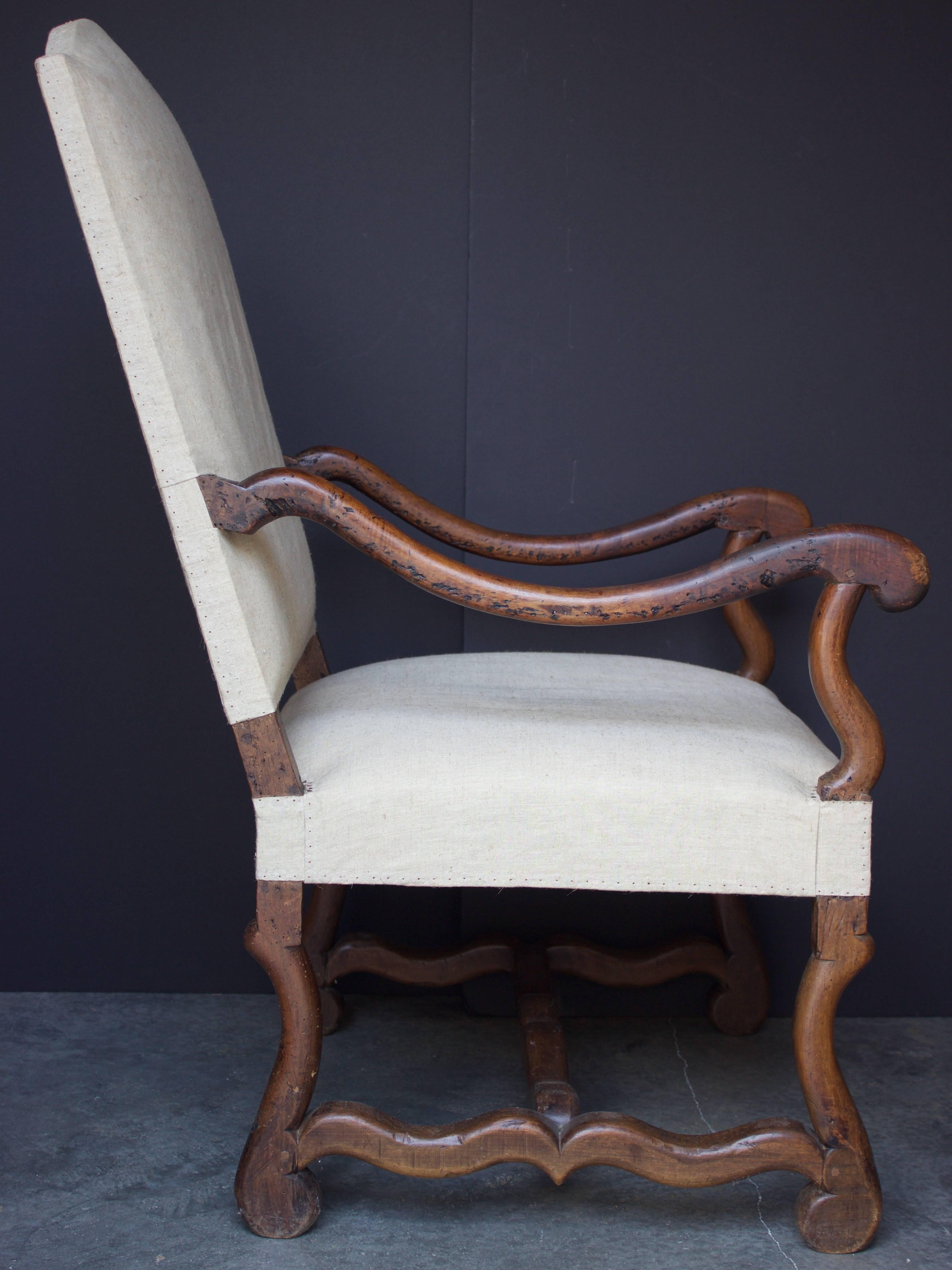 A very comfortable large fauteuil made of solid walnut. Tall and slightly slanted backrest with its top in 'chapeau de gendarme