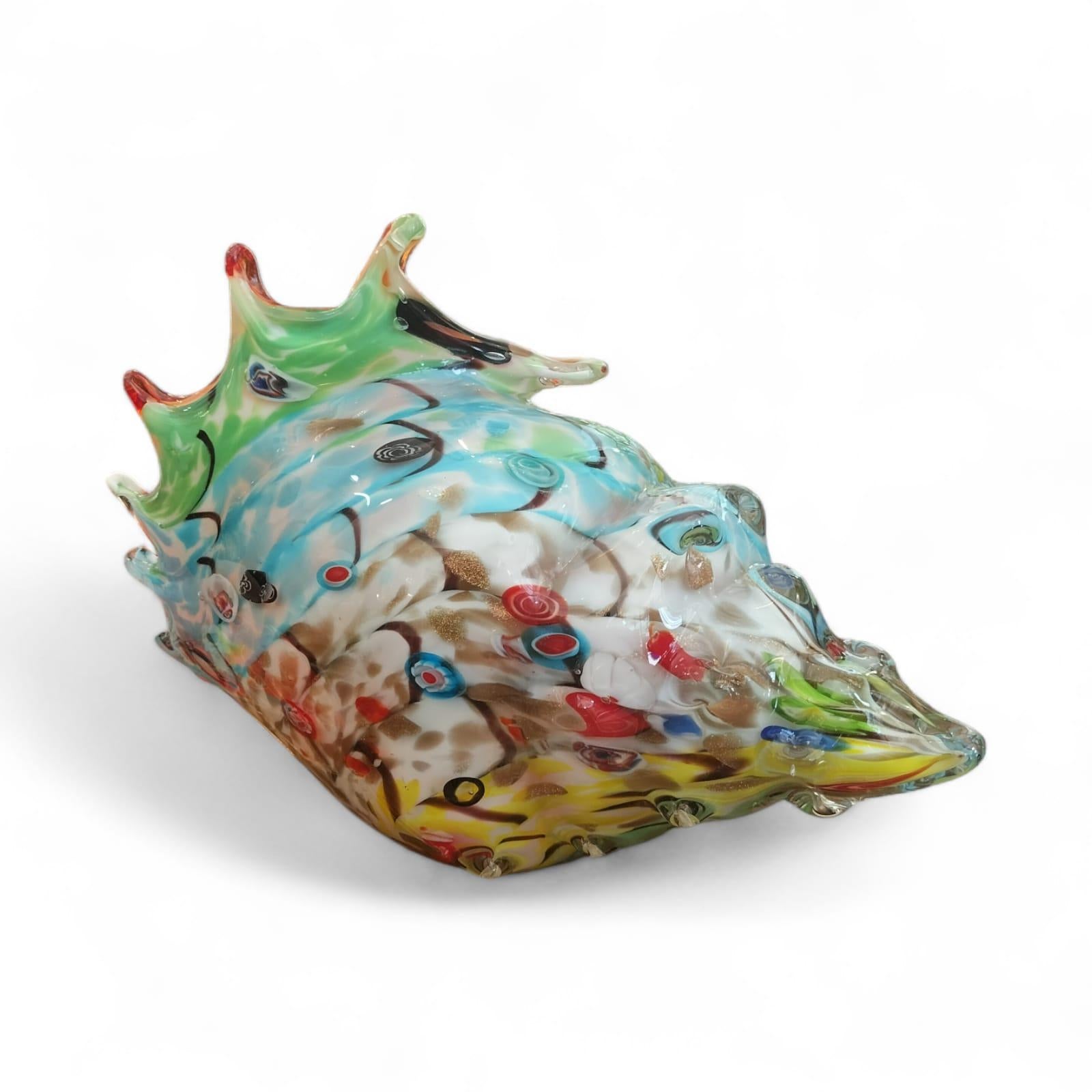 Solid mixed coloured Murano glass shell. Swirls of blue mixed in with green, yellow, red and dashes of amber and black and clear finish.

