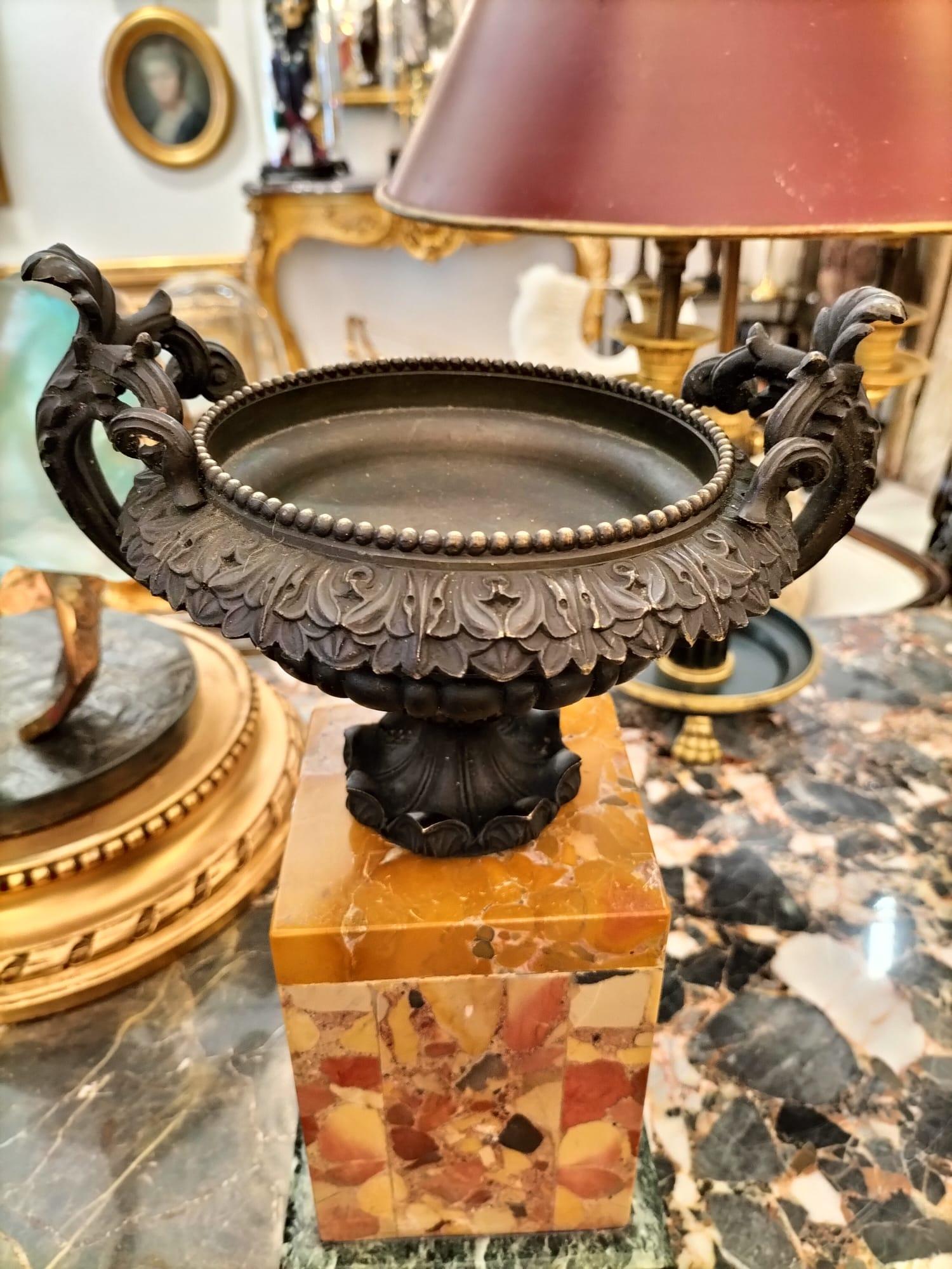 We are delighted to present you with this pair of Empire cassolettes originating from the 19th century. 

They are crafted from bronze and mounted on a Aleppo breccia marble base. The patinated bronze cups are adorned with bear Empire-style