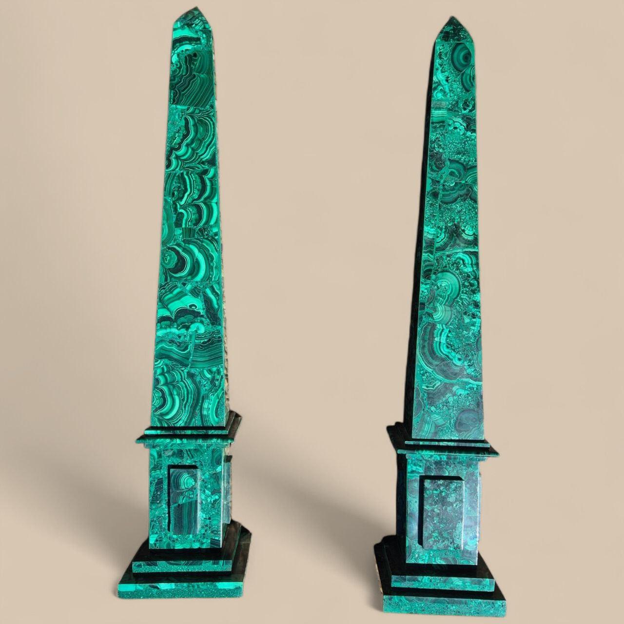 Une paire monumentale d'obélisques en malachite, d'une hauteur remarquable de 60 cm. Sculptées dans la plus belle malachite naturelle, ces pièces se distinguent par leurs superbes nuances de vert et leurs motifs veinés hypnotiques, uniques à chaque