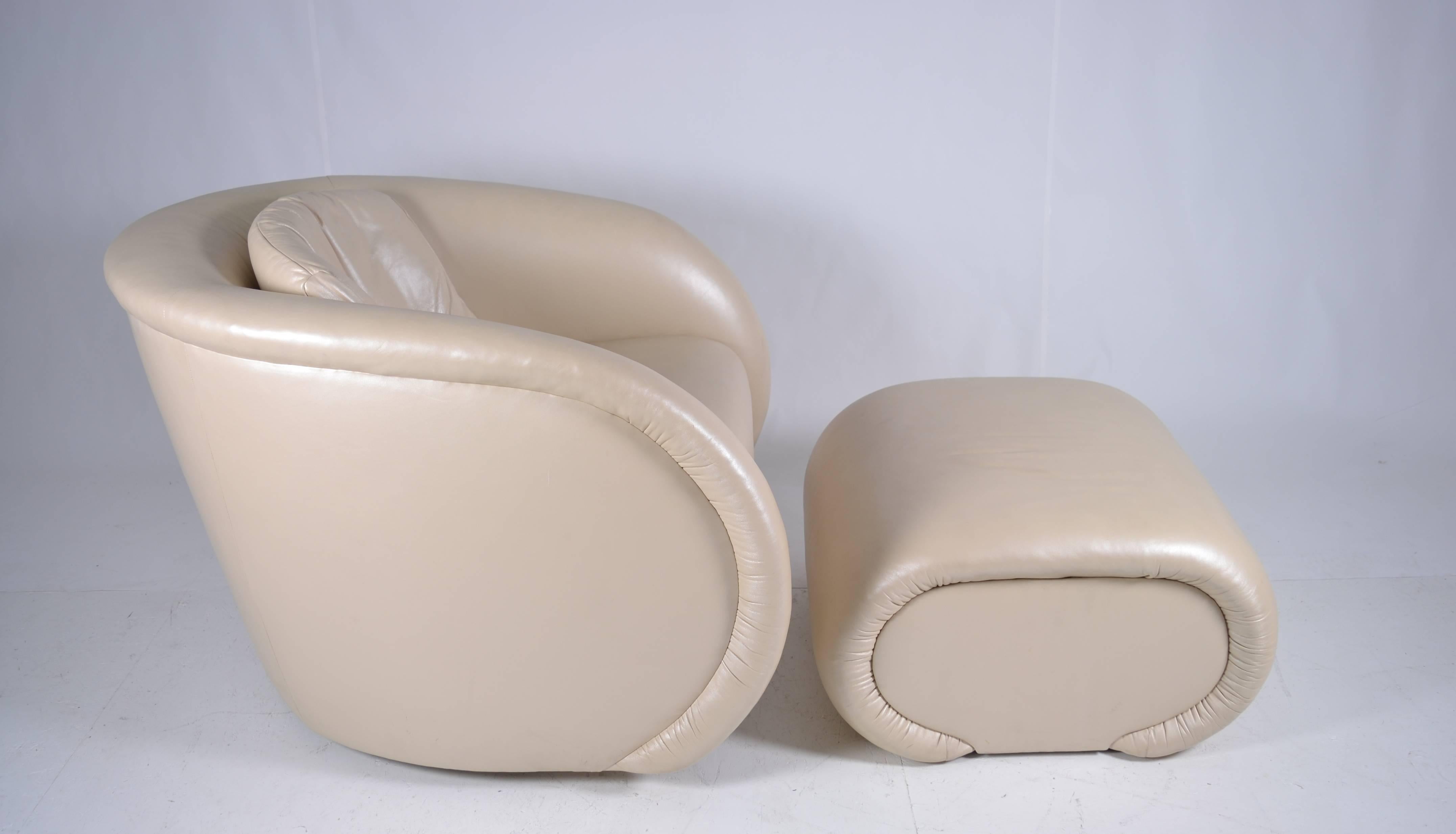 So sculptural. Comfortable arm chair with matching ottoman in creamy pearlized leather. Very good condition. Nice label on original upholstery: Preview Furniture.