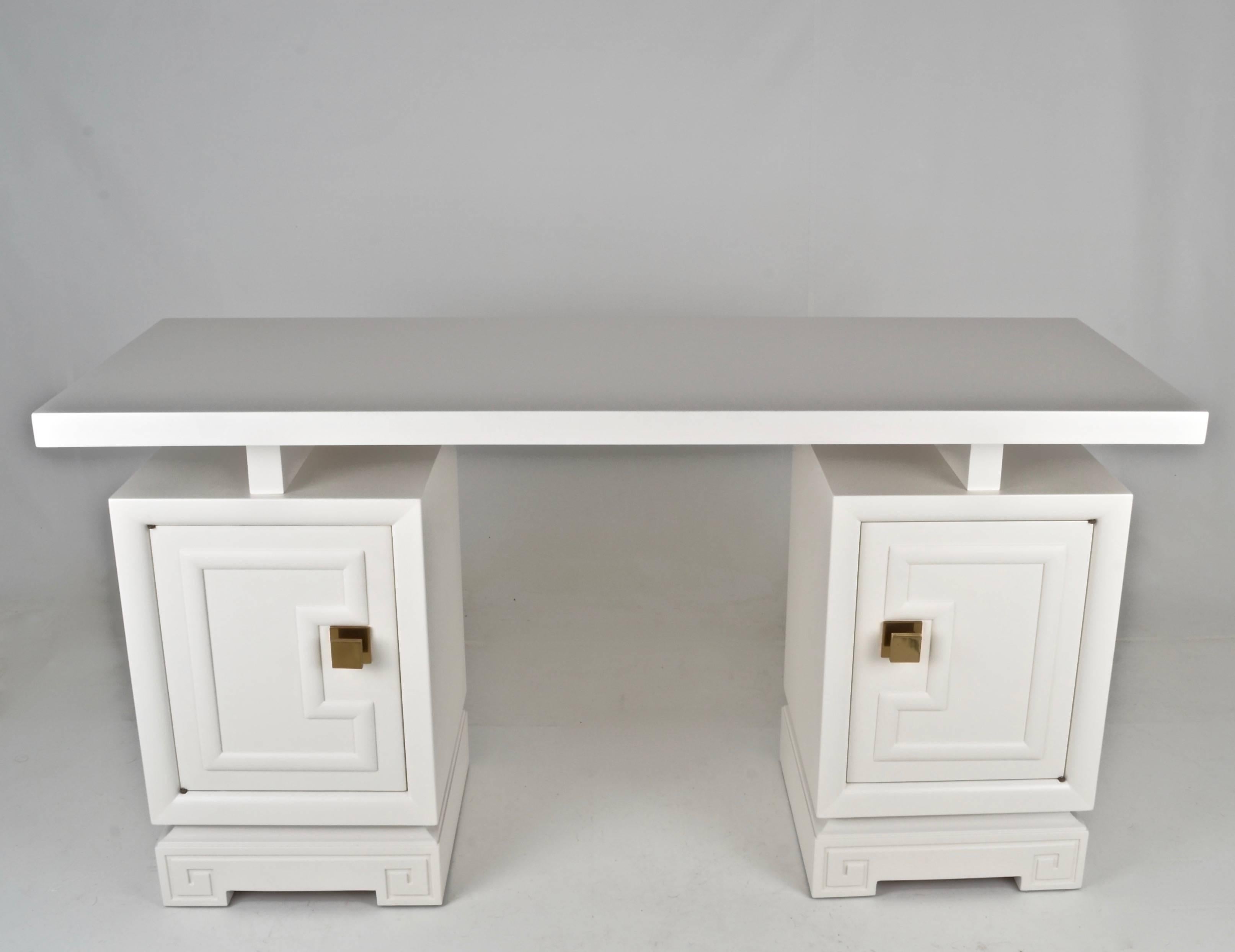 Newly lacquered in satin finish dove white lacquer, this is a charming desk/dressing table/sofa table/bar. Very Fine quality construction with heavy square brass pulls. Fitted interior drawers behind two doors. Finished back allows piece to be