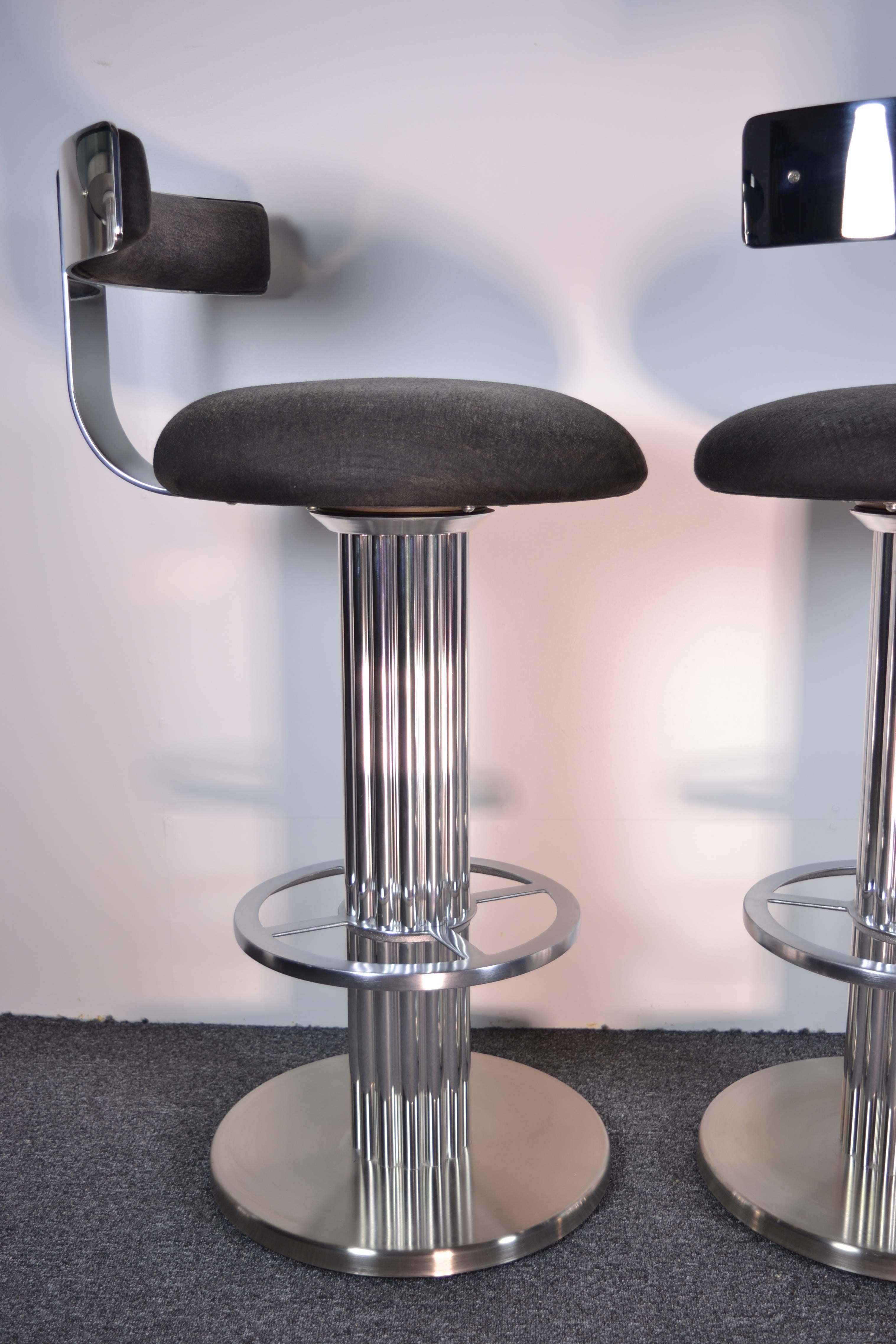 Polished steel and brushed aluminum stools by Designs for Leisure, exceptionally fine quality. Very heavy with smooth swivel motion. Excellent condition with almost no signs of wear on metal frames. Covered in faux snake printed fabric quite faded