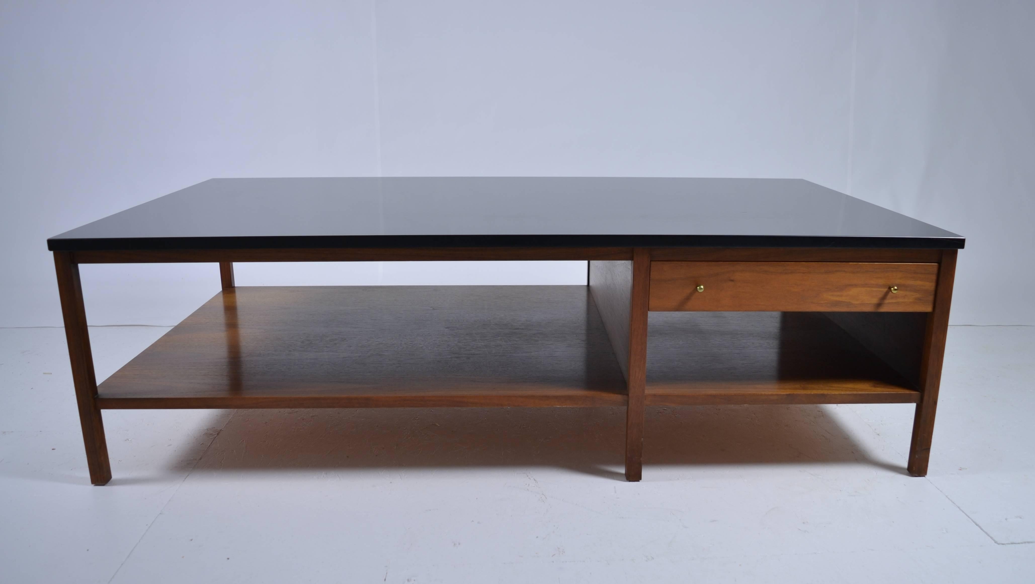 Handsome example of classic McCobb cocktail table, in walnut with a relatively unusual heavy black vitralite glass top. Single drawer with original pulls.