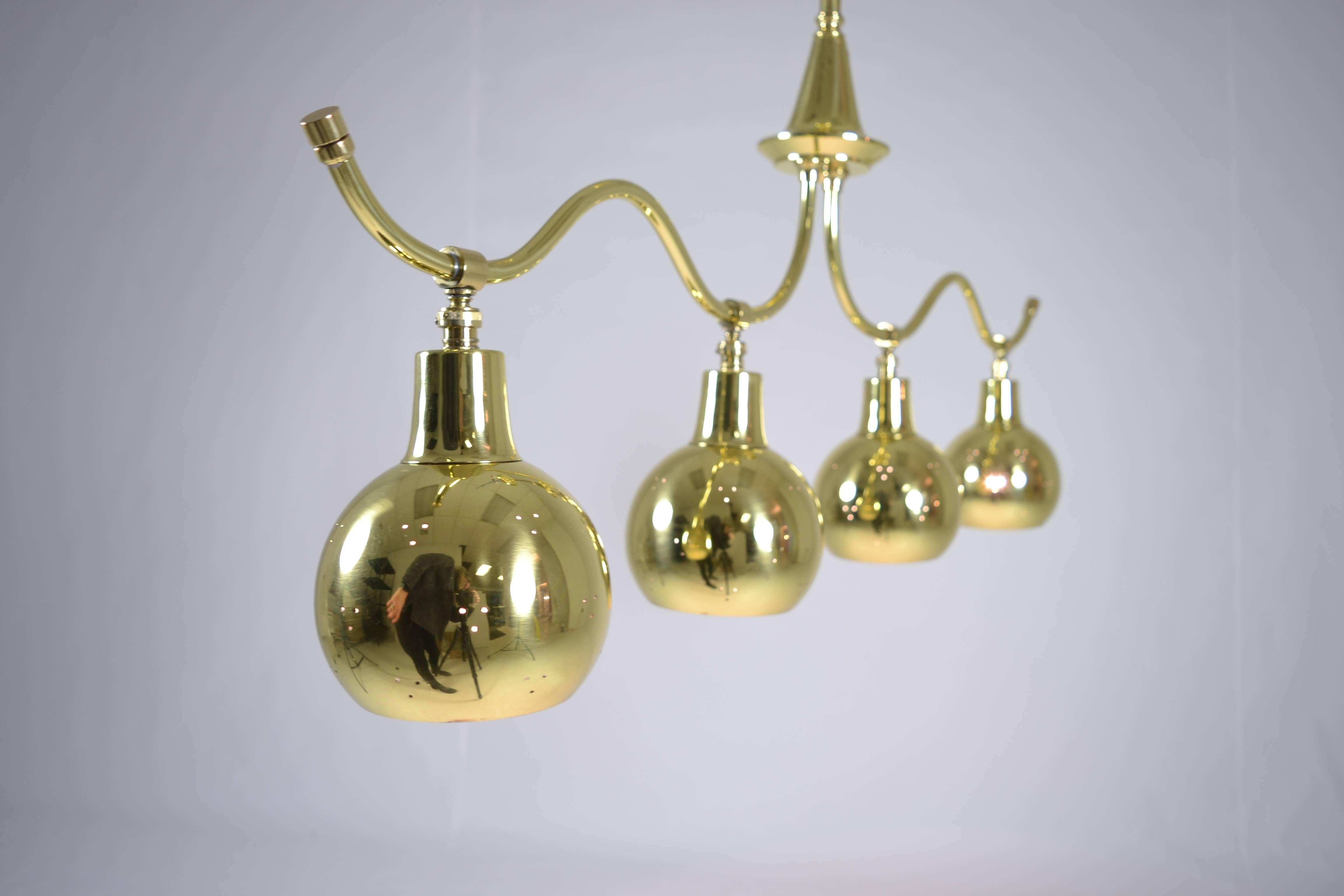 Great form in a quality fixture featuring four brass lamps, each with a swivel fitting allowing light to be directed. Each shade is pierced with pin prick decoration. Newly wired, polished and lacquered.
