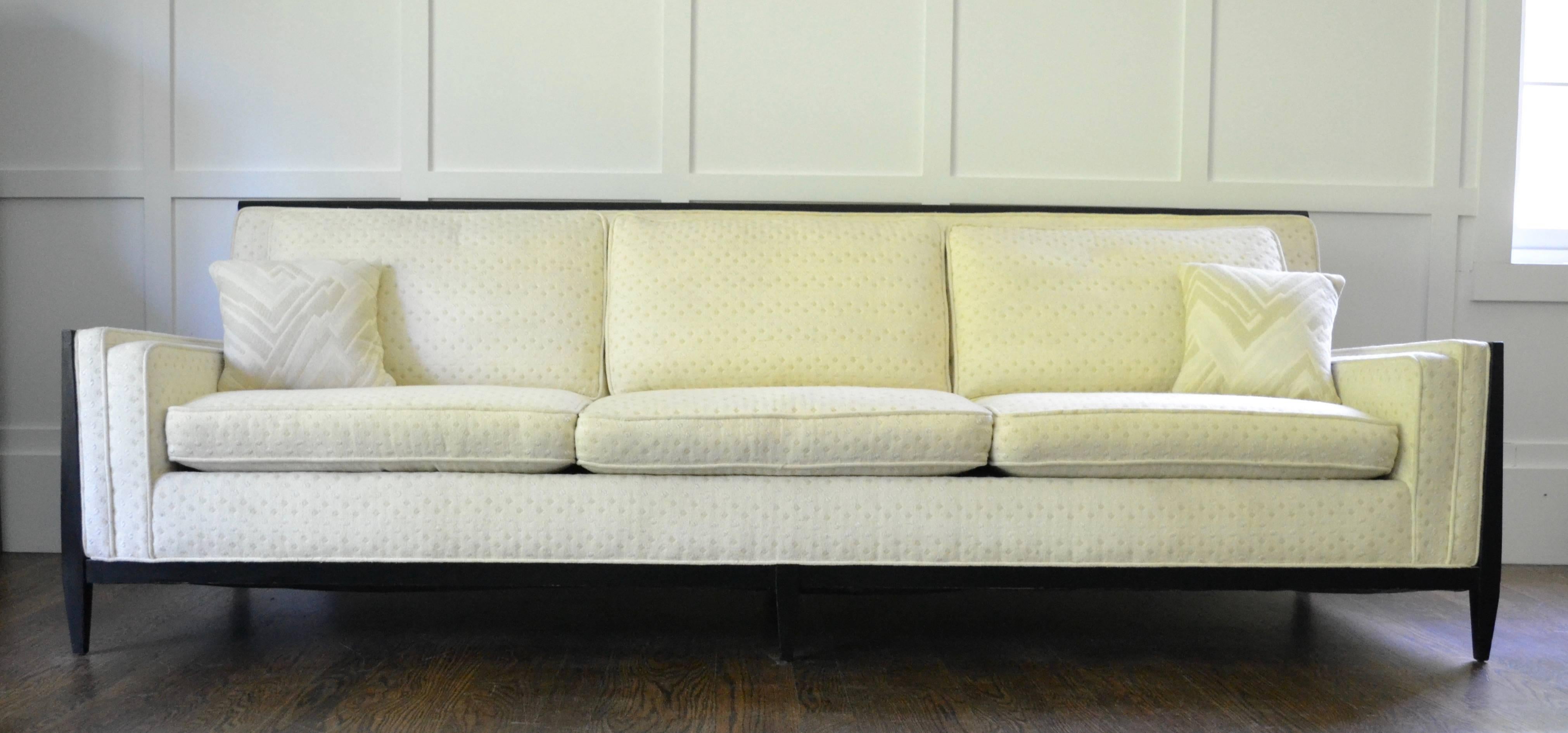 Nice sized three-seat sofa by Paul McCobb with handsome sculptural details. Ebonized wood frame with six legs in very good condition. Back cushions are quality feather/down. Woven fabric is in good condition with only slight wear.